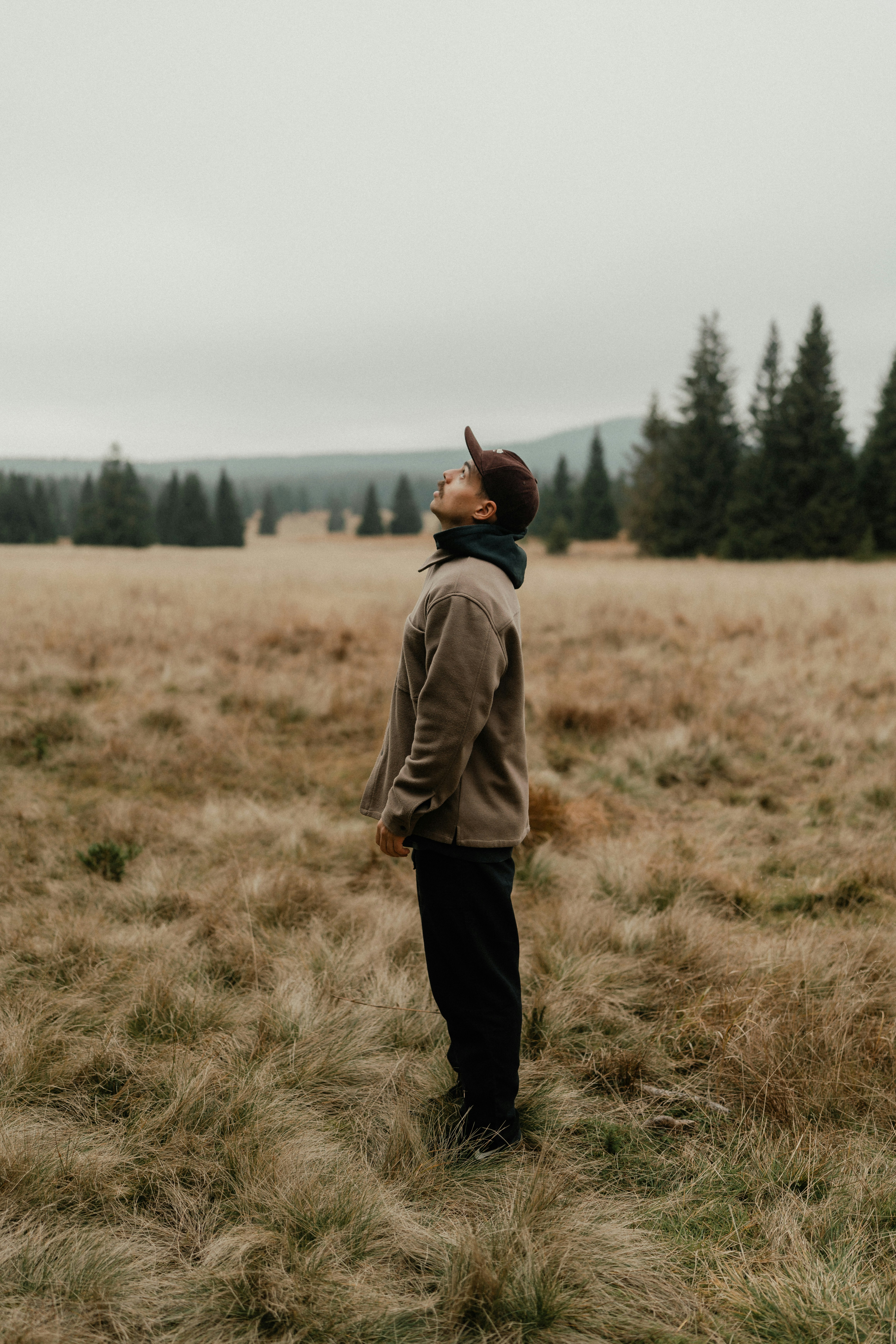 A person standing in a field with trees in the background