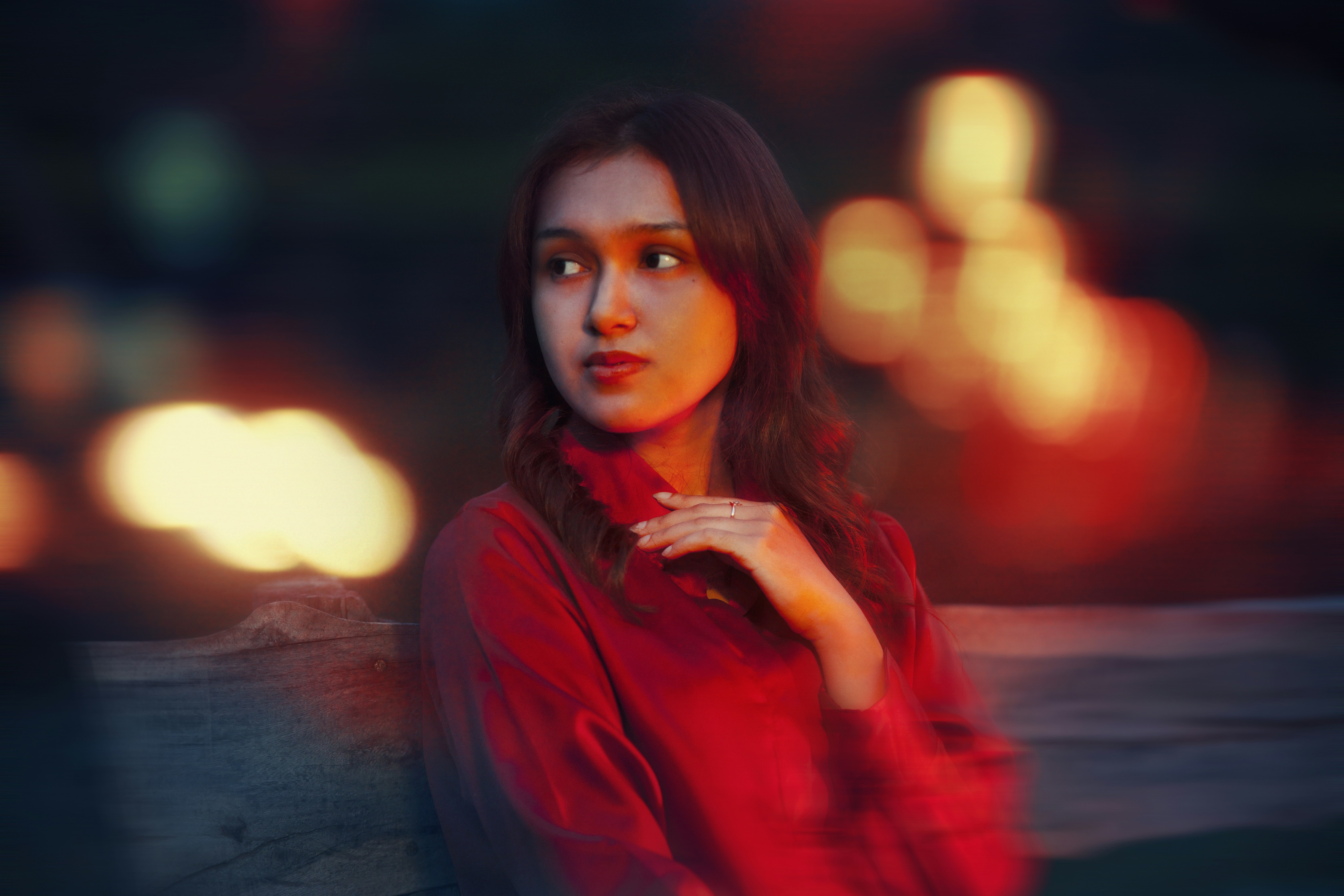 Seorang wanita berbaju merah berpose untuk berfoto