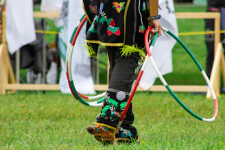 A young child with a pair of skis and a hula hoop