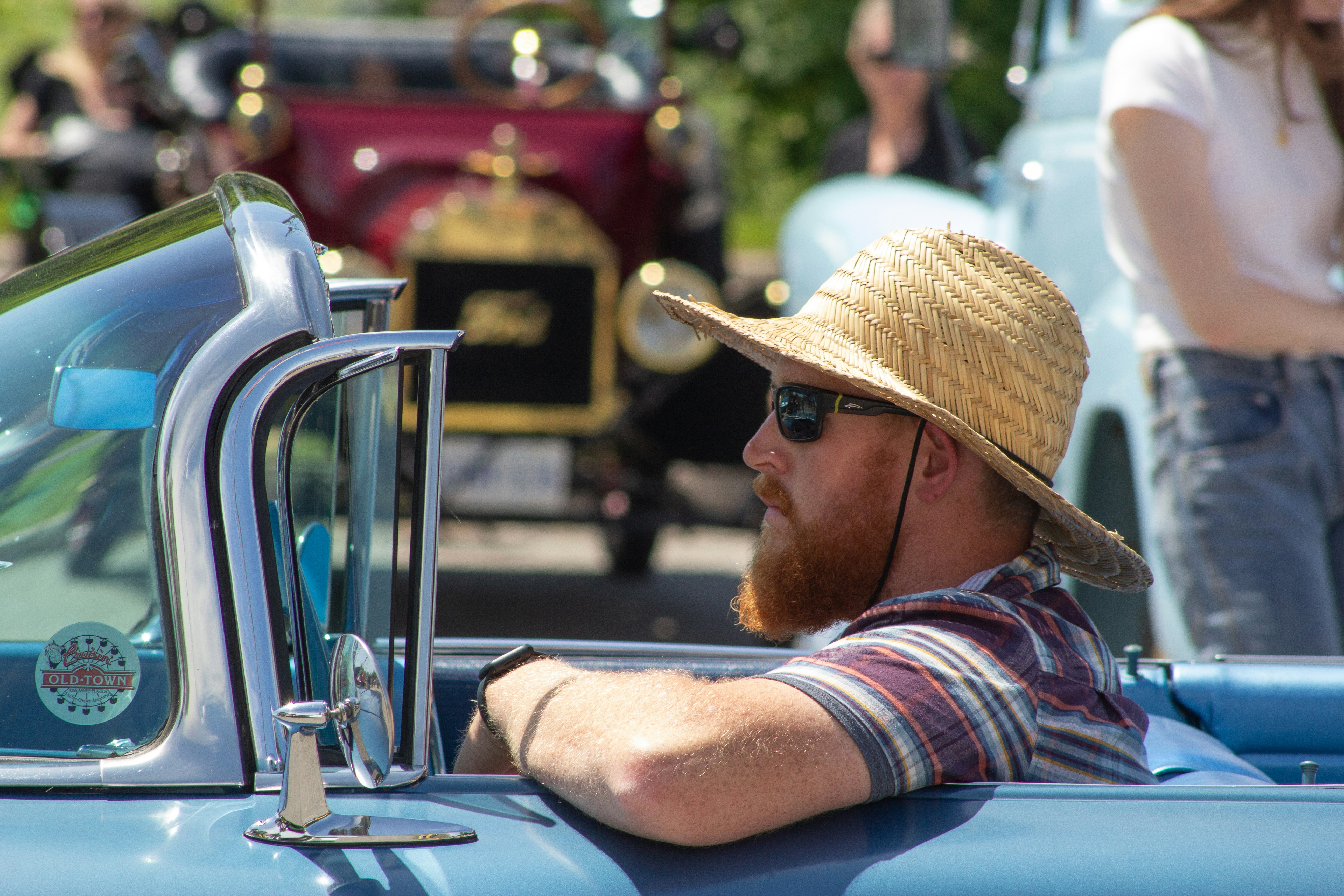 Un homme au chapeau de paille assis à l’arrière d’un camion bleu