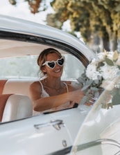 A woman sitting in a car holding a bouquet of flowers