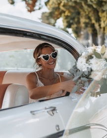 A woman sitting in a car holding a bouquet of flowers