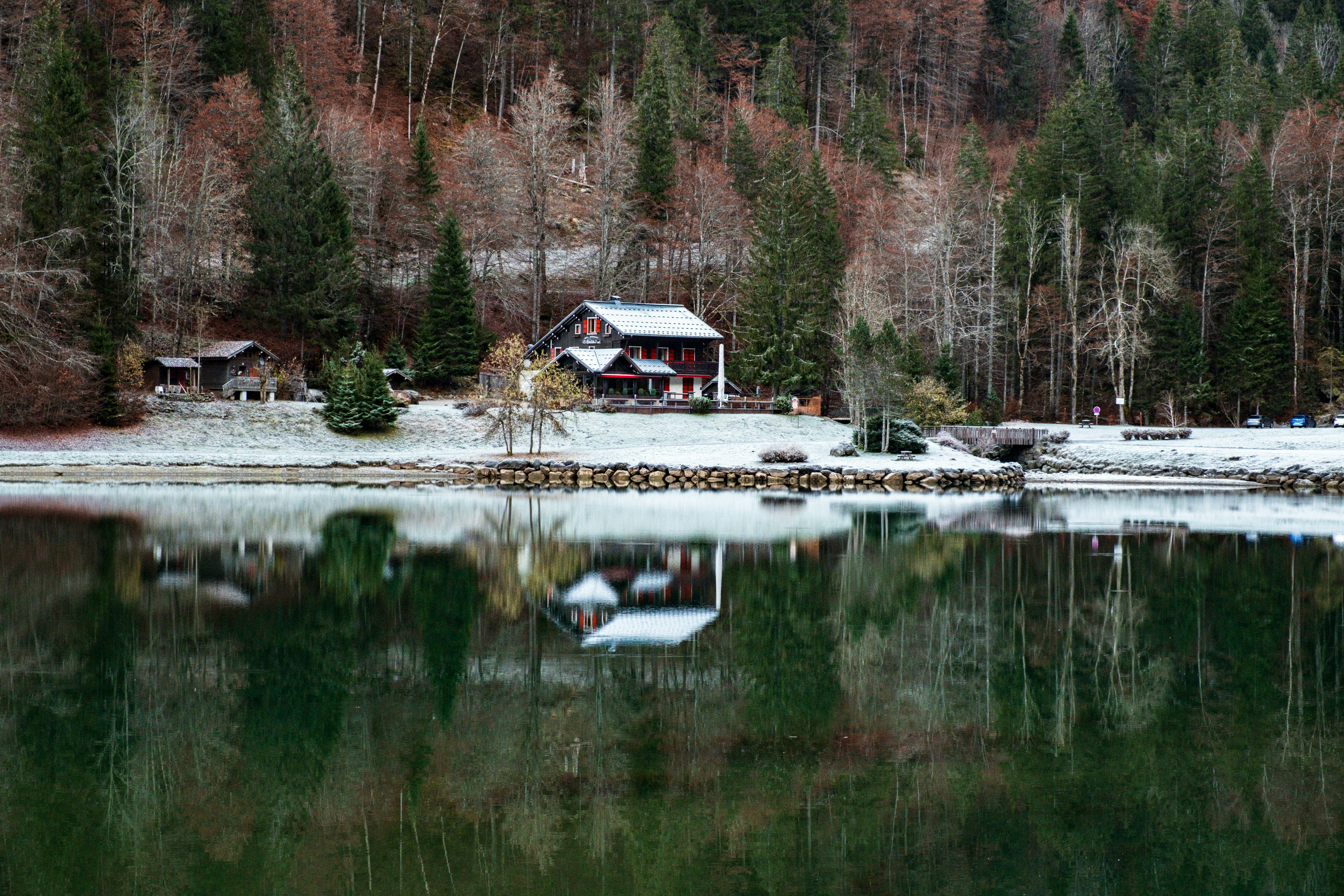 A small cabin sits on the shore of a lake