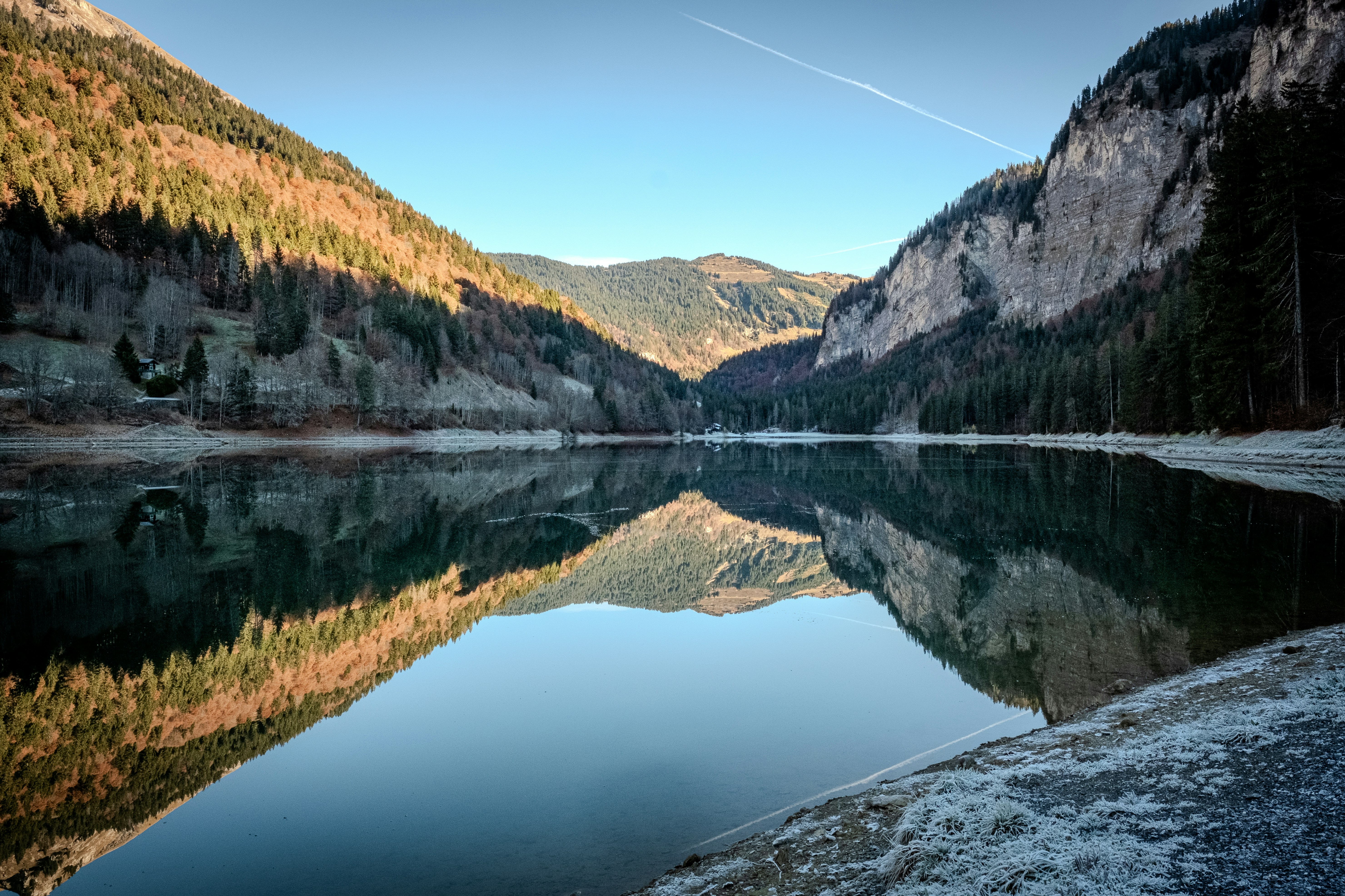 A lake surrounded by mountains with a clear sky