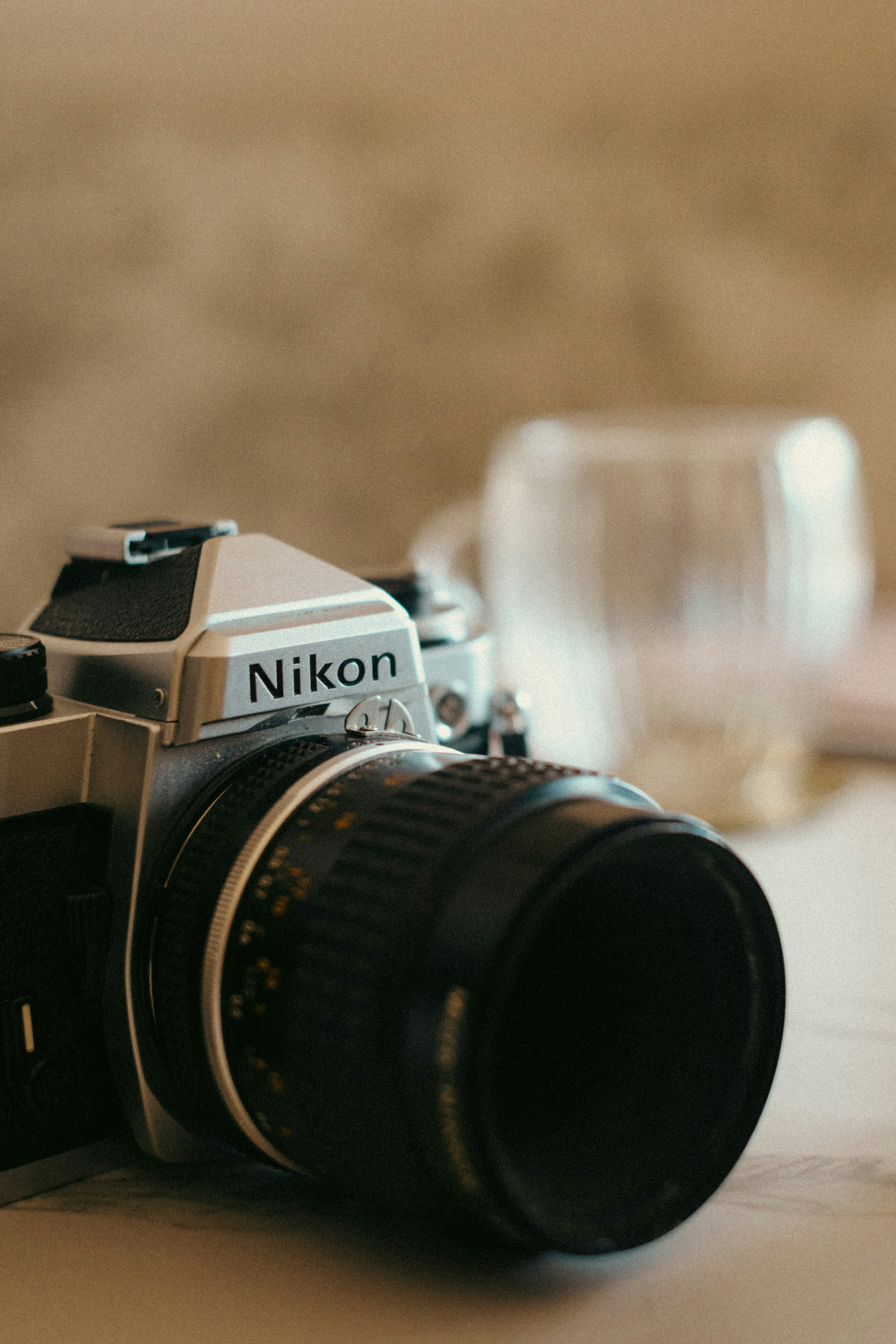 A camera sitting on top of a table next to a glass