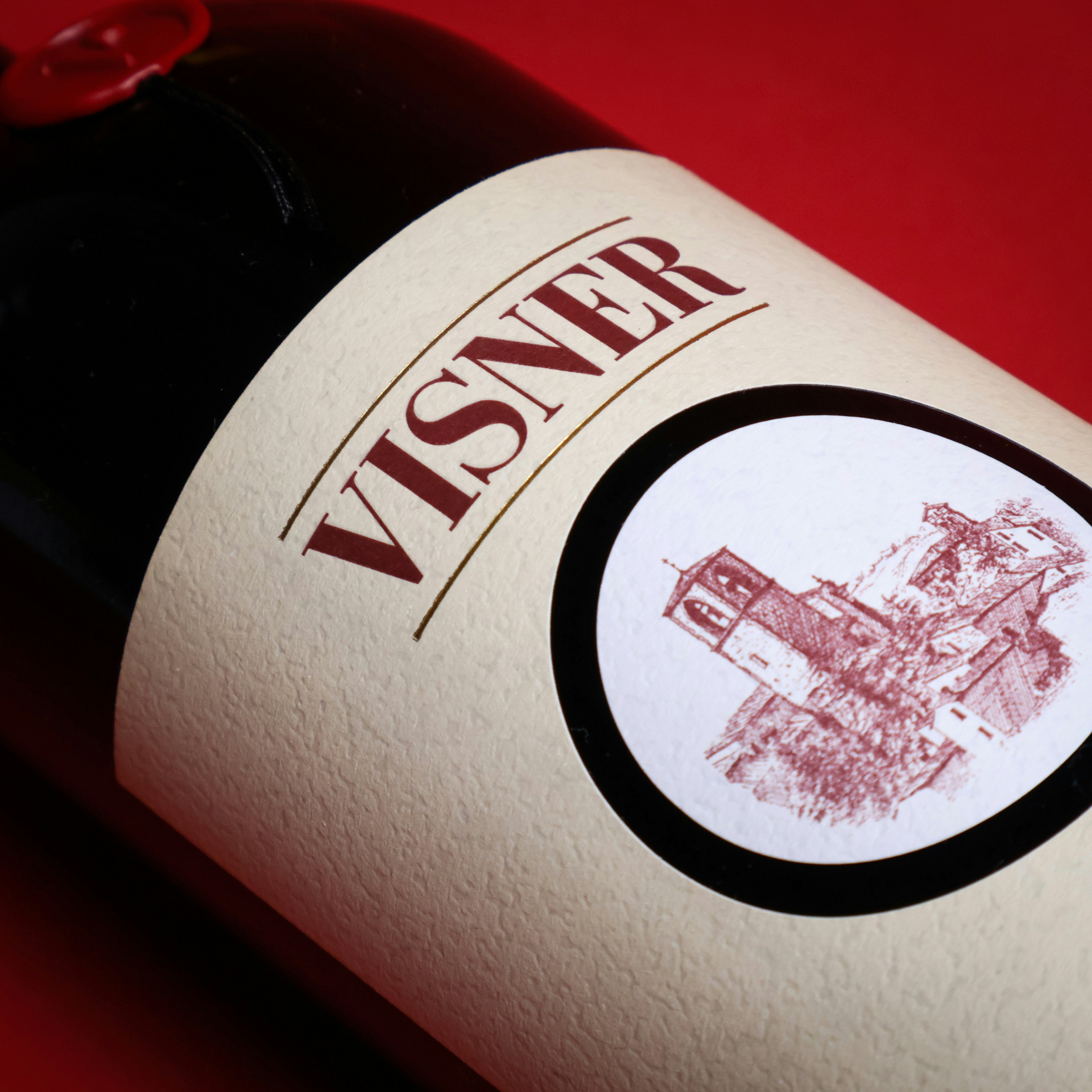 A bottle of wine sitting on top of a red table
