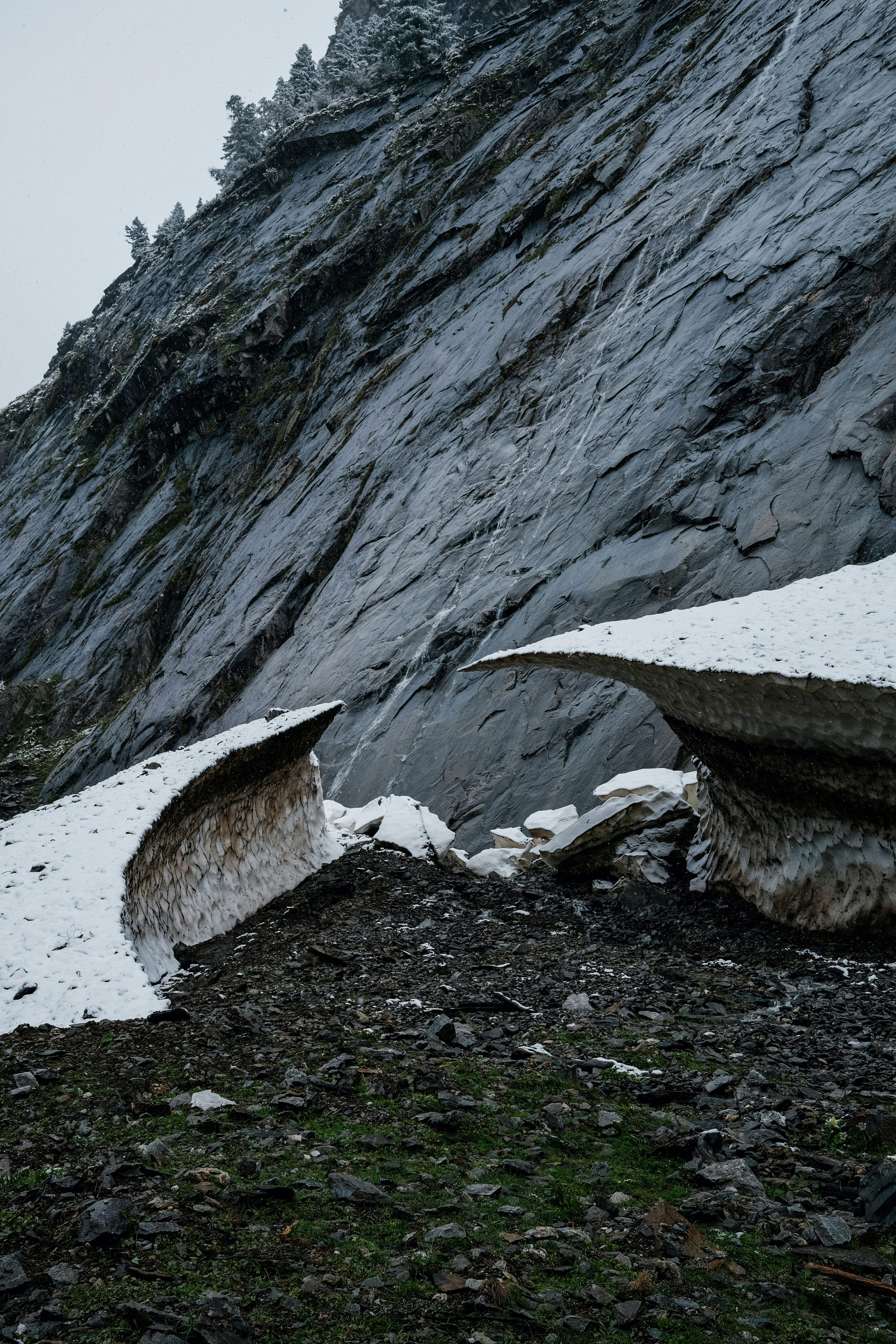 A snow plow sitting on the side of a mountain