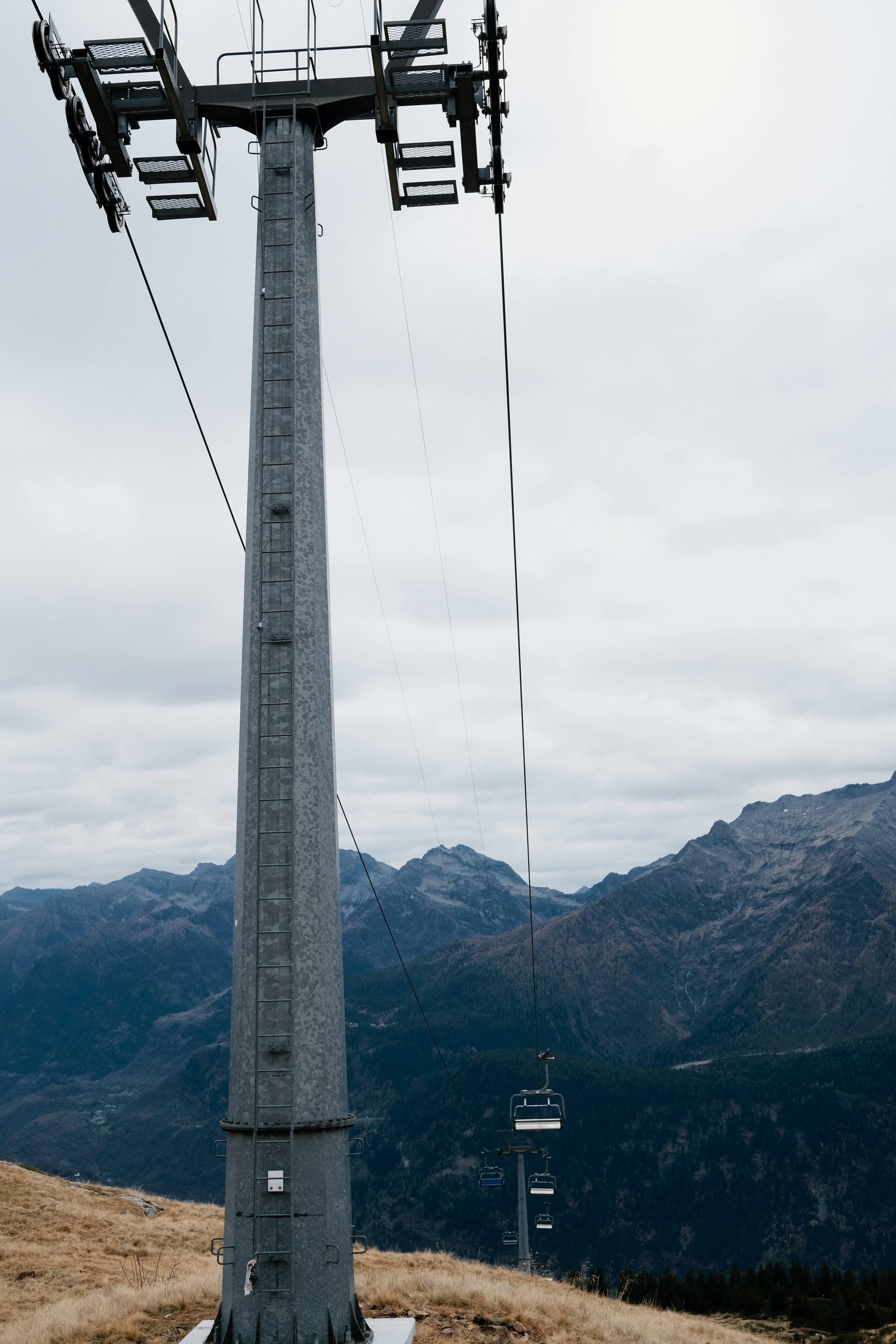 A ski lift going up a hill with mountains in the background