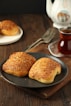 Two biscuits on a plate next to a cup of tea