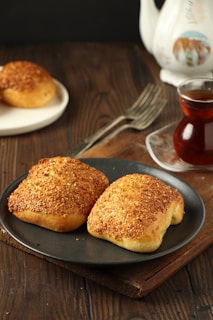 Two biscuits on a plate next to a cup of tea