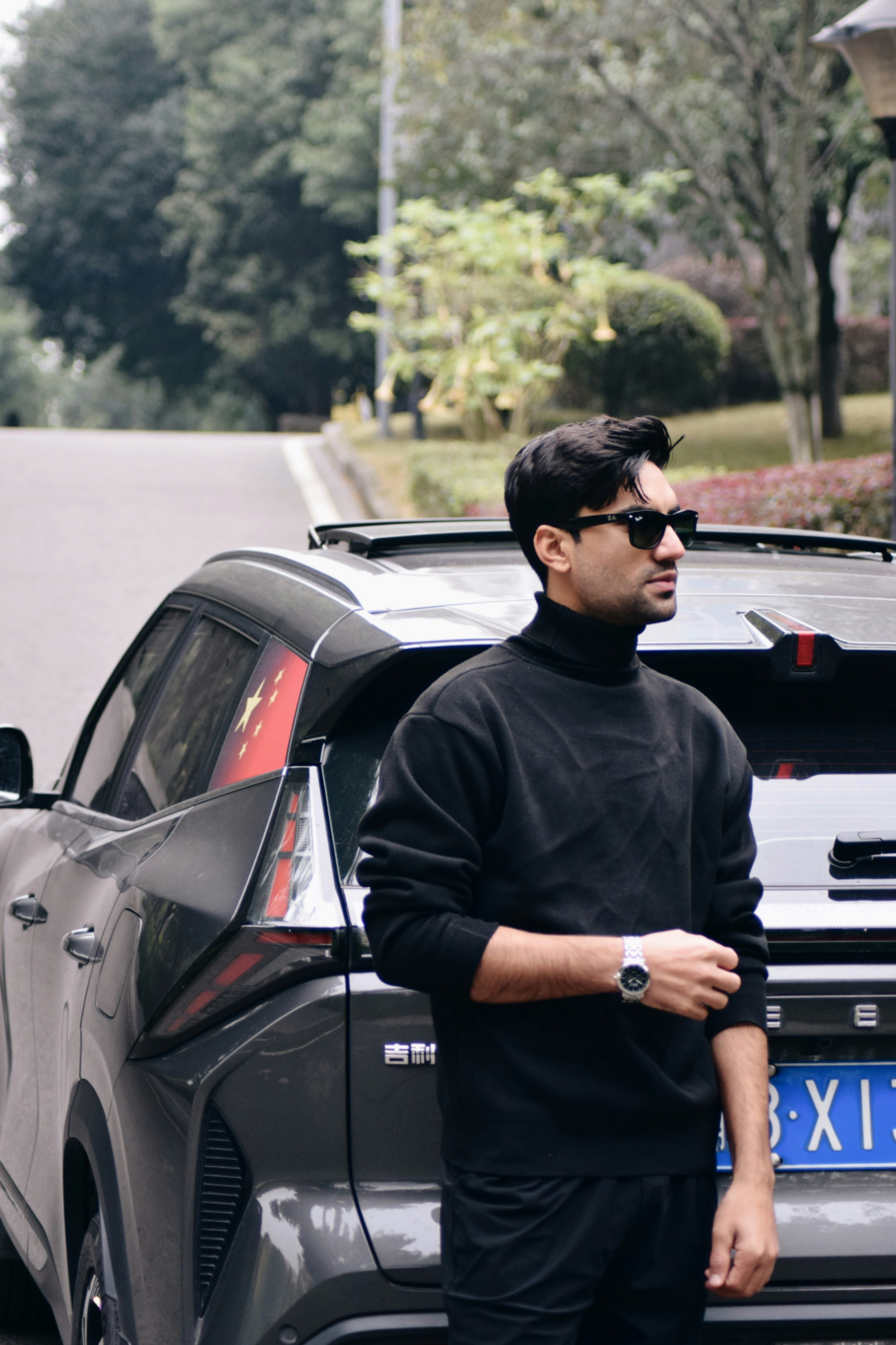 A man standing next to a parked car