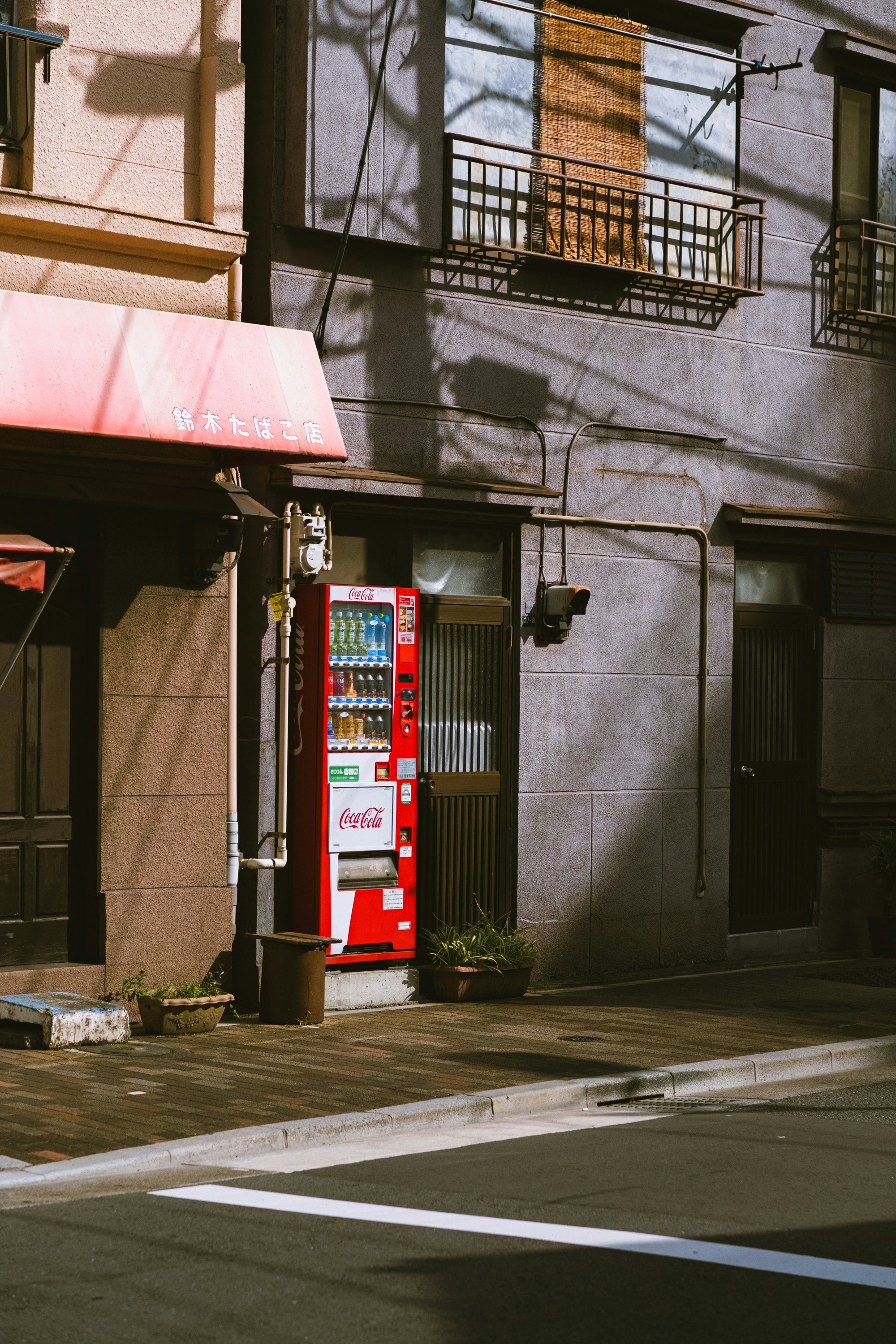 A red phone booth sitting on the side of a street