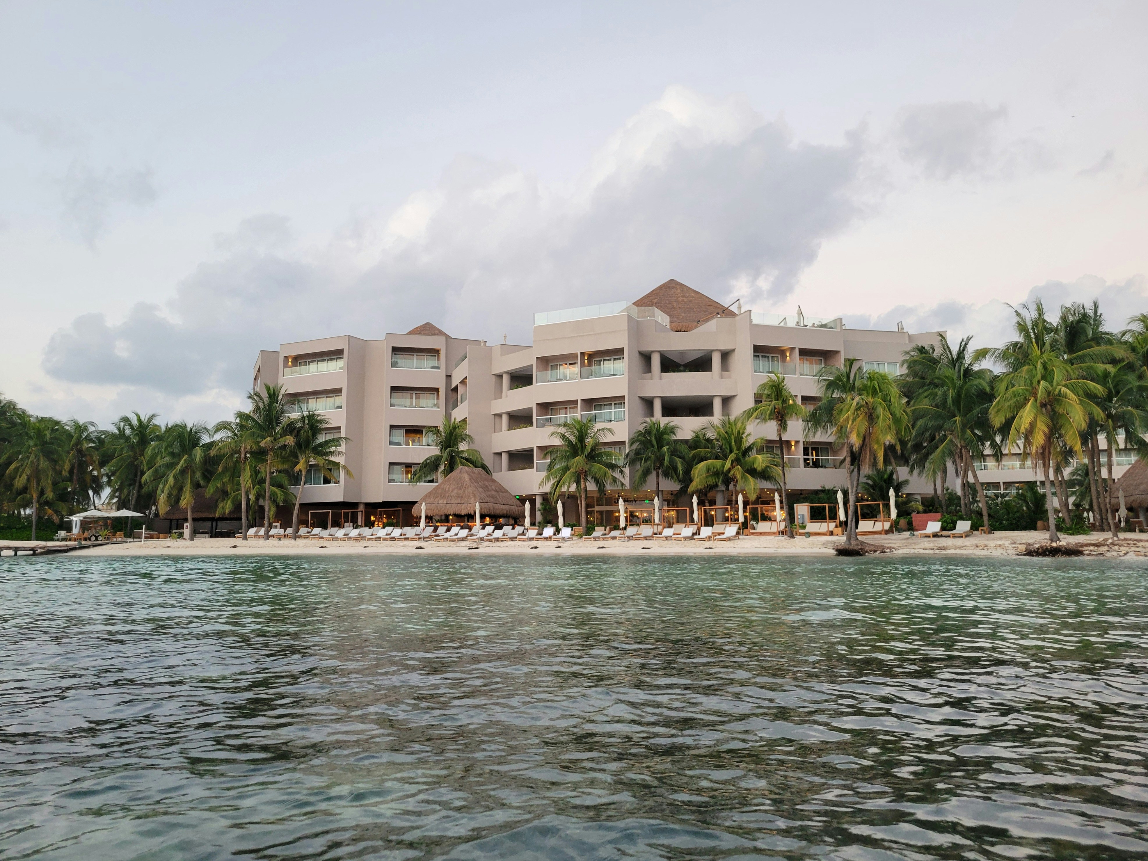 A large building sitting on top of a beach next to the ocean, 