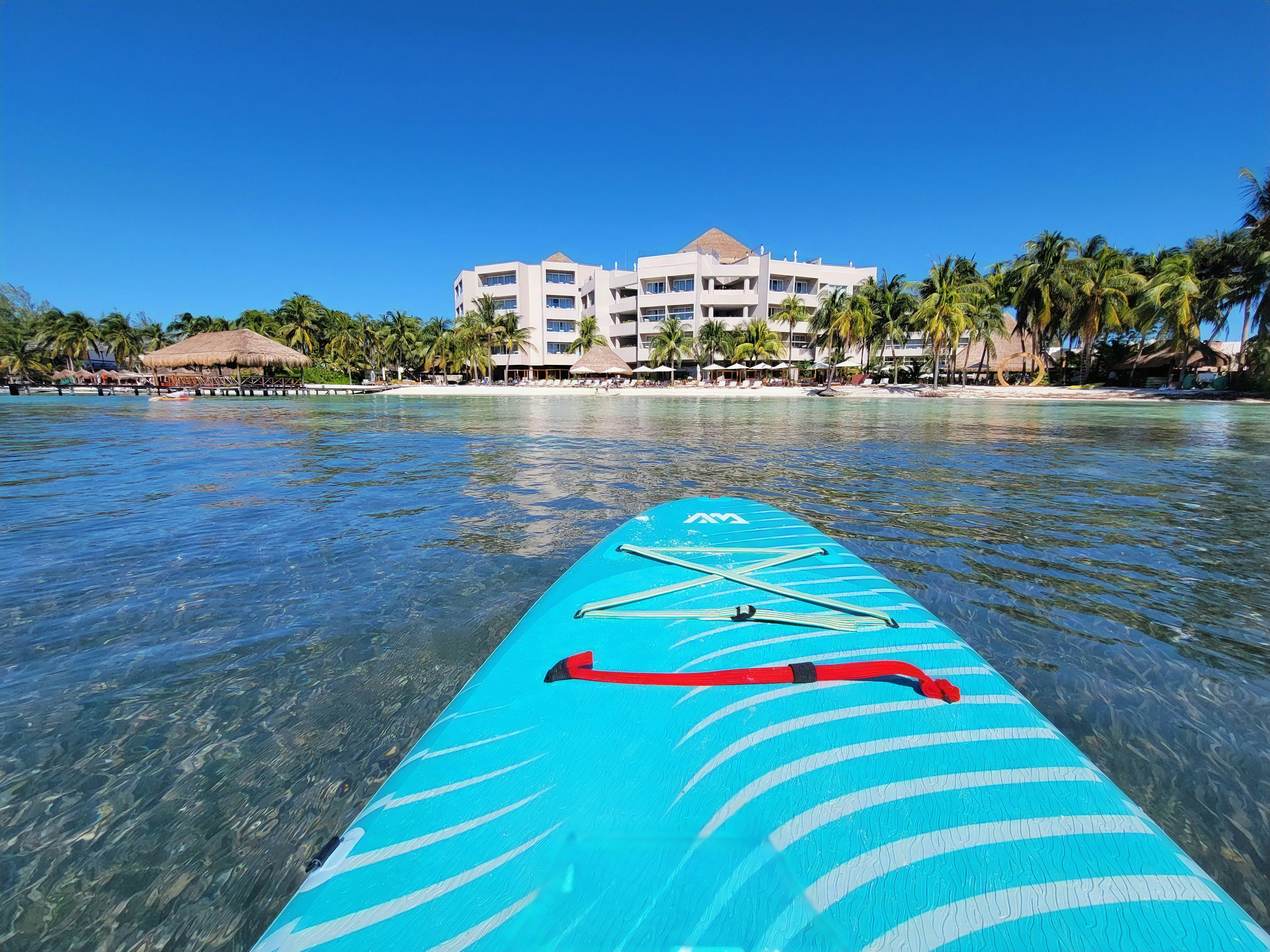 A blue surfboard sitting in the middle of a body of water, 