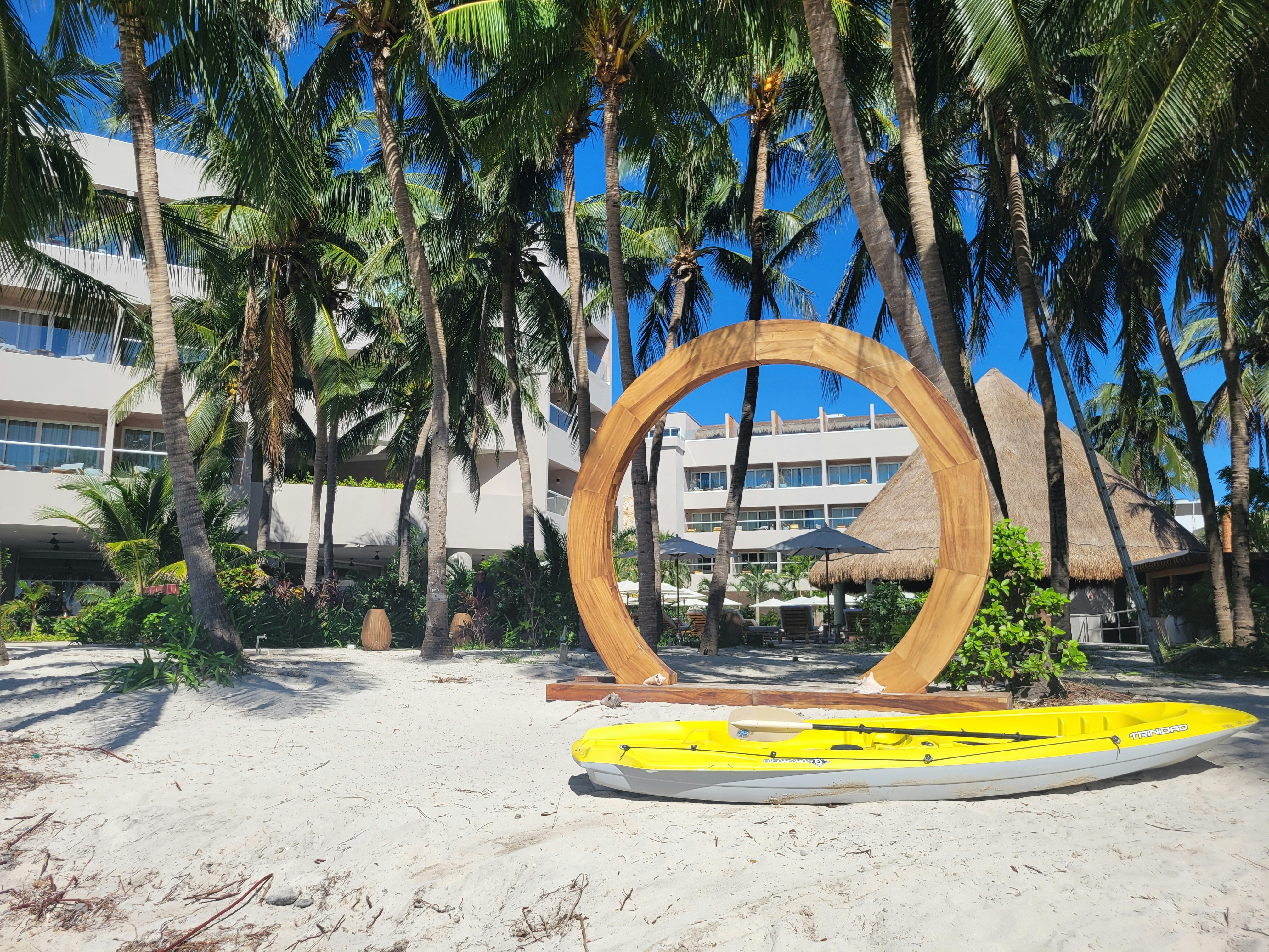 A surfboard on a beach with a hotel in the background