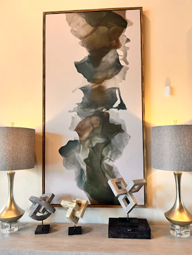 A painting and two lamps on a table
