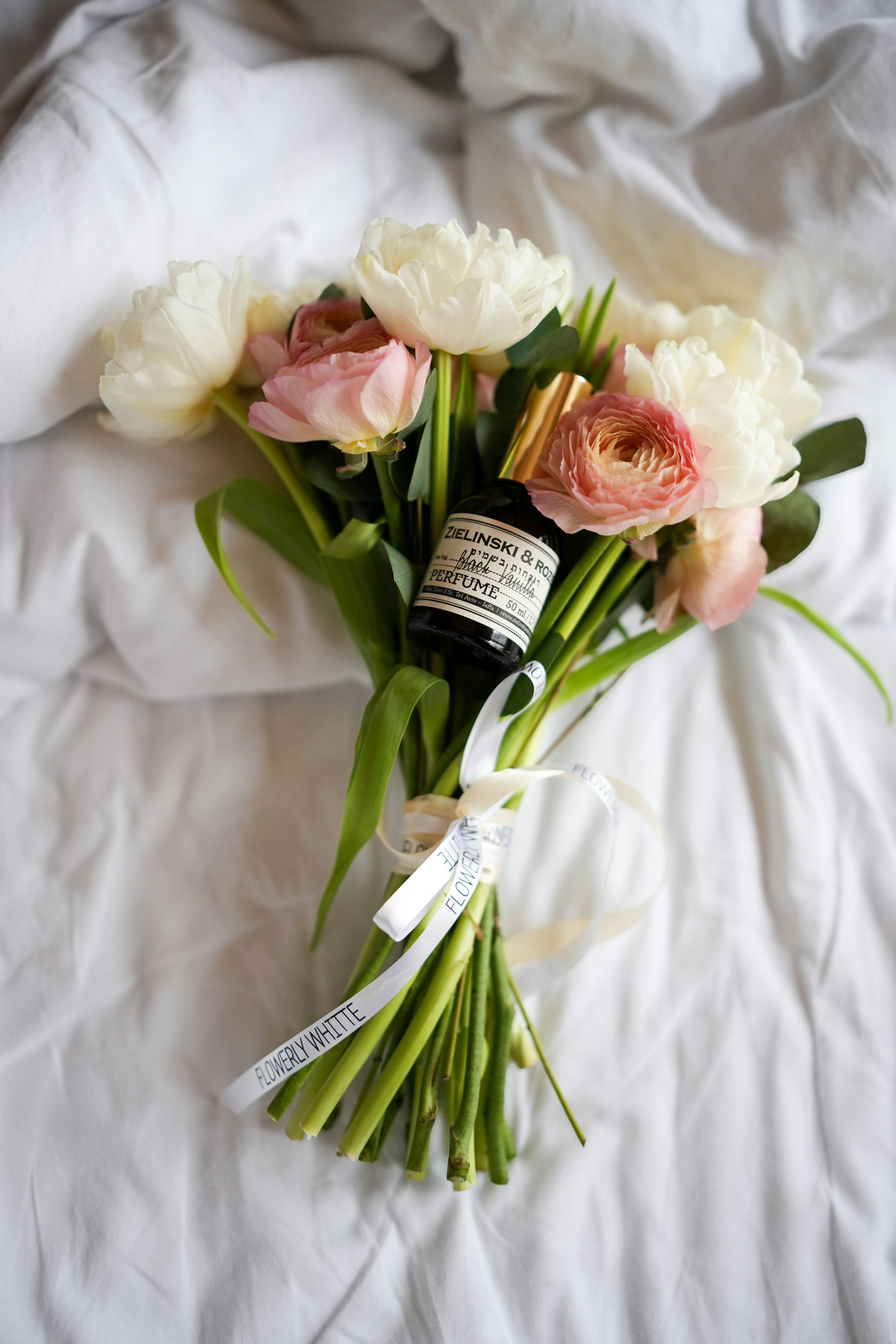 A bouquet of flowers laying on a bed