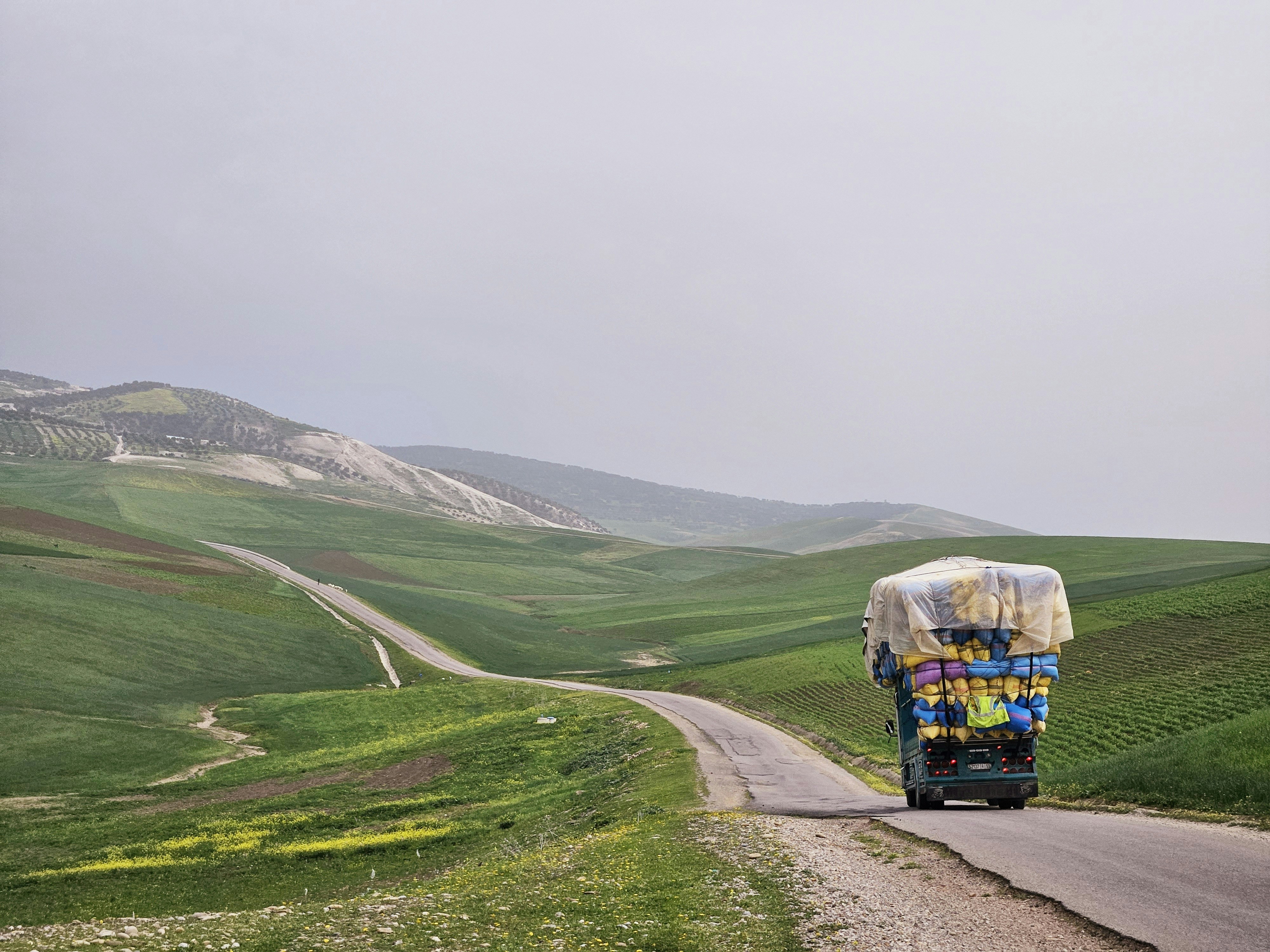 A truck driving down a road in the middle of nowhere
