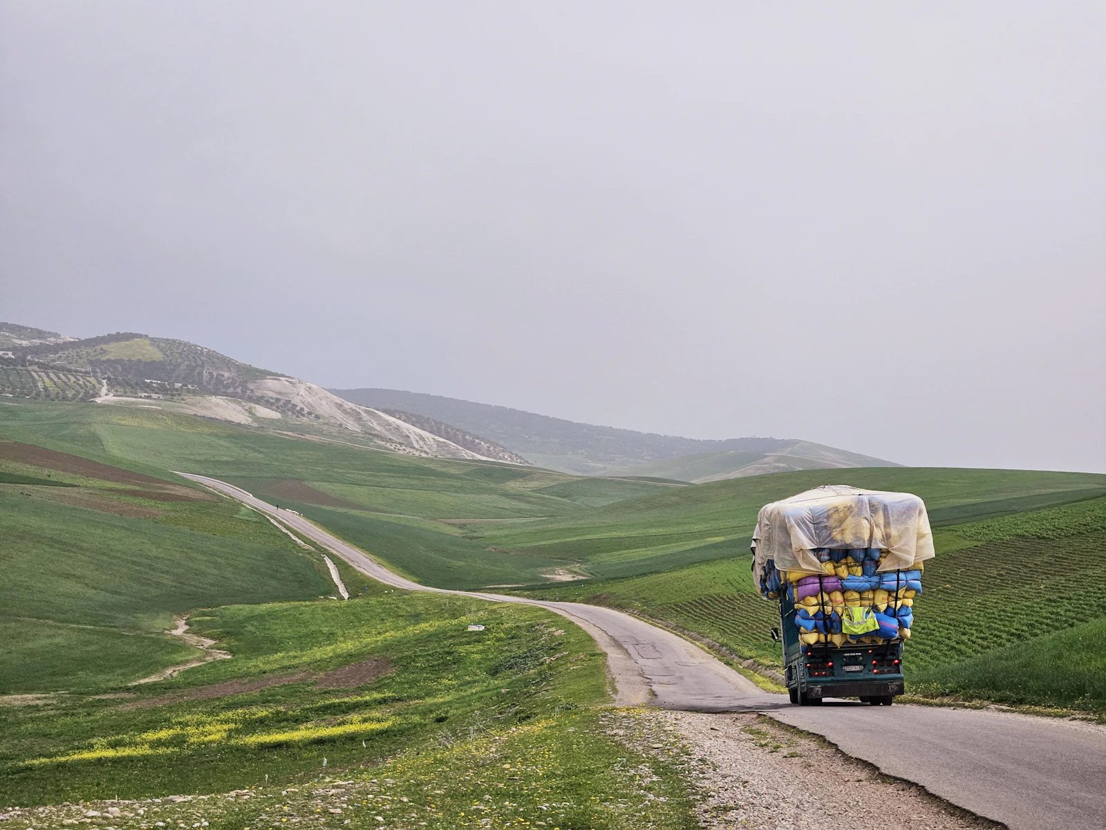 A truck driving down a road in the middle of nowhere