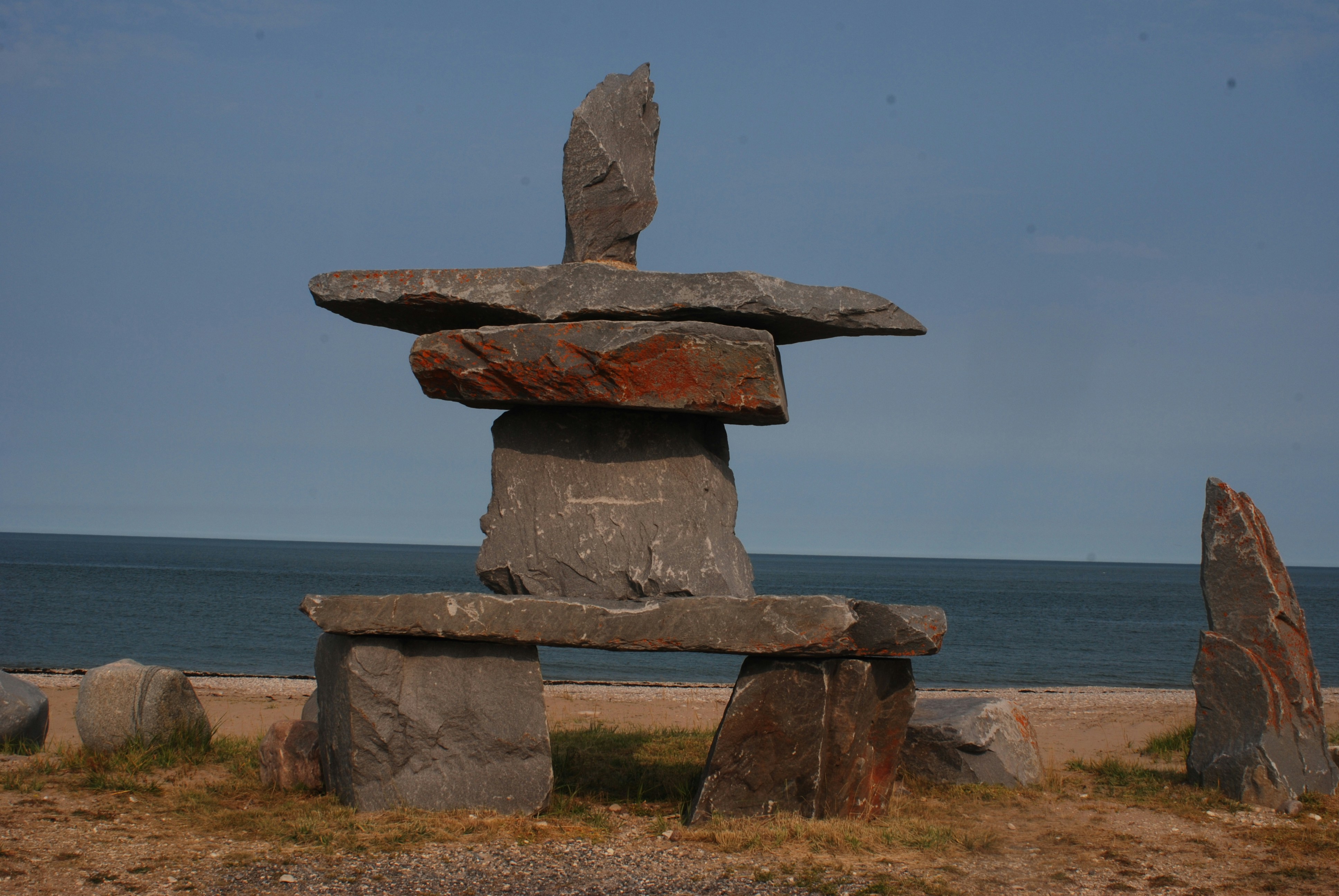 A stone bench sitting on top of a sandy beach