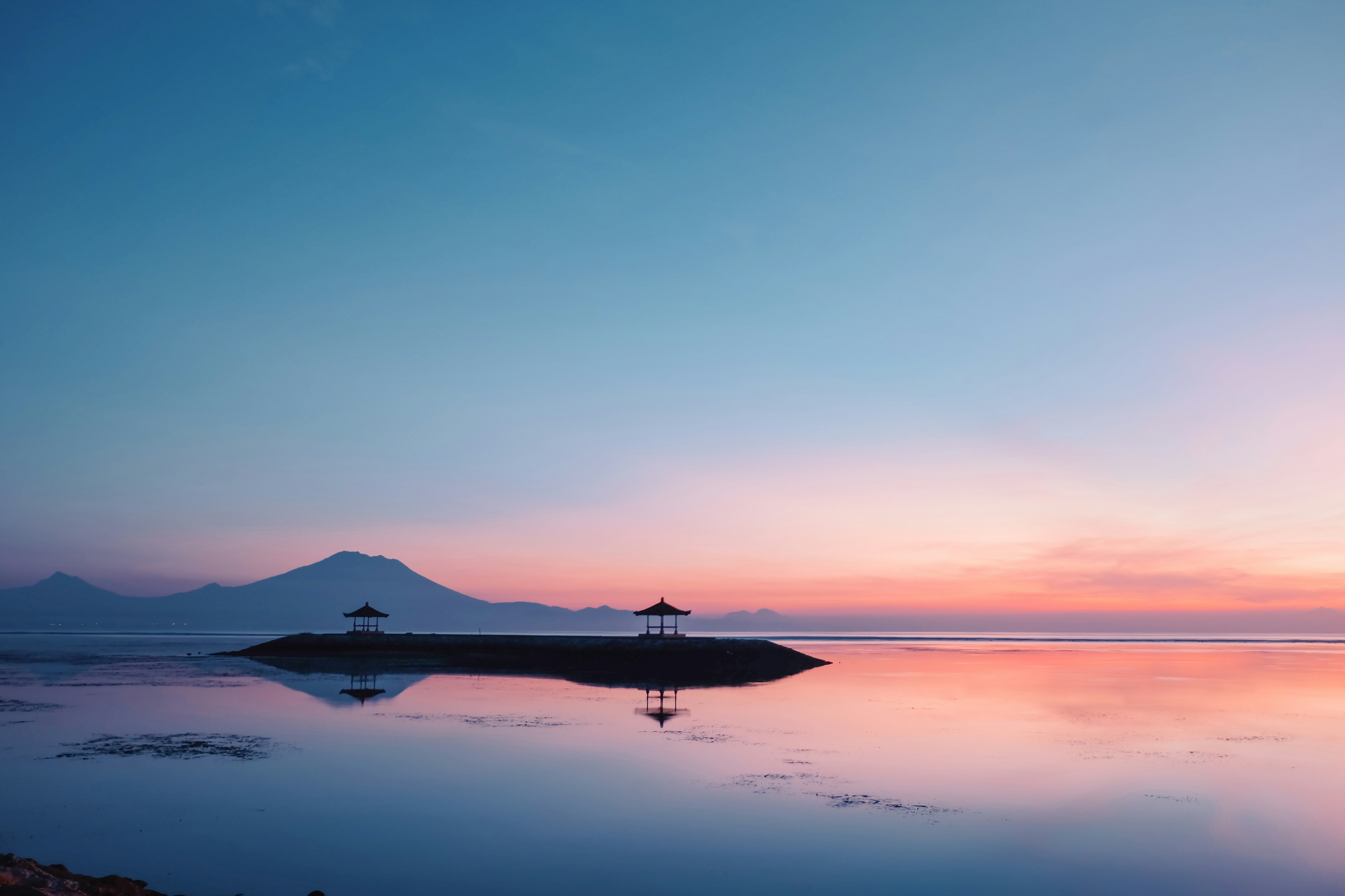 A large body of water with a mountain in the background