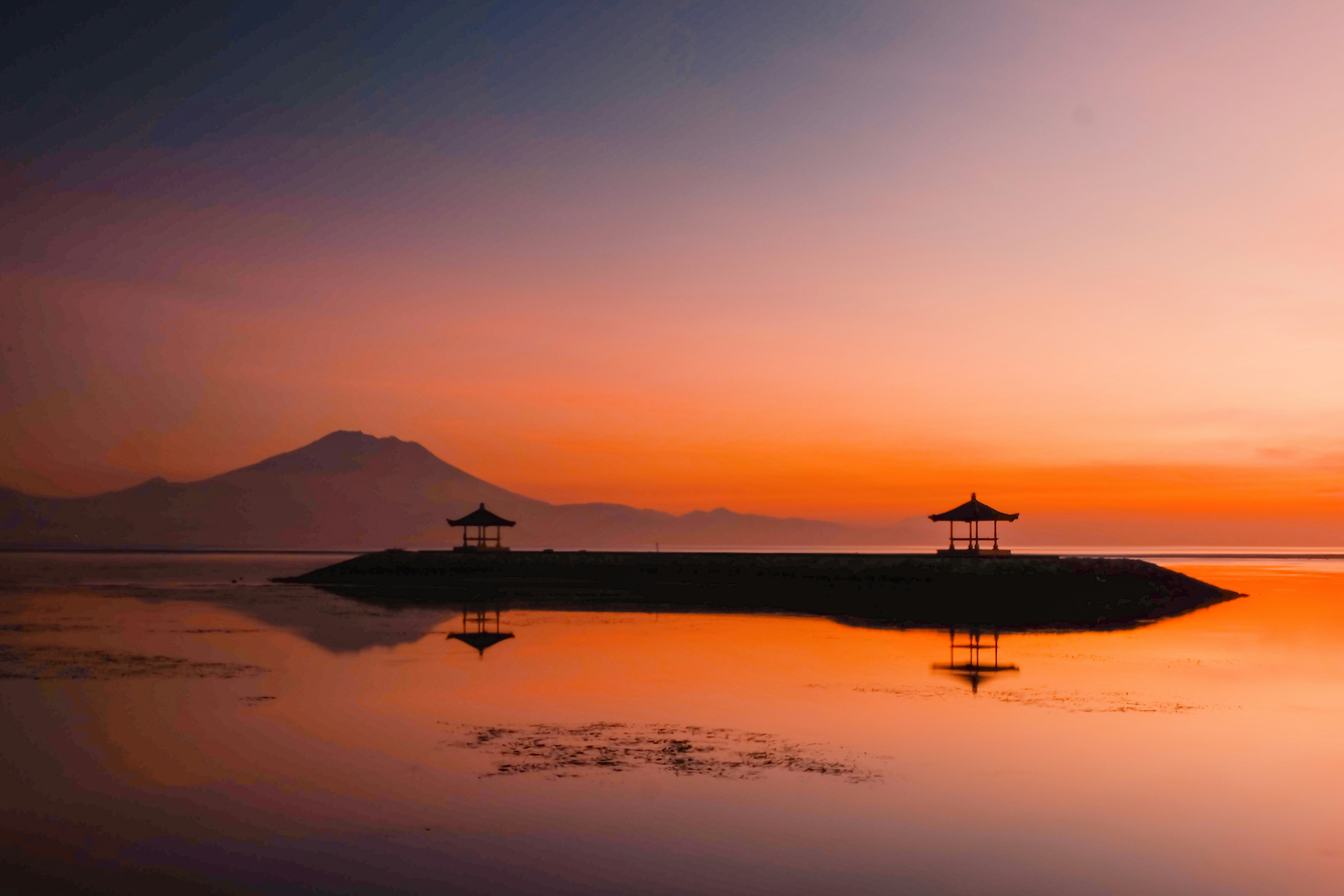 A body of water with a mountain in the background