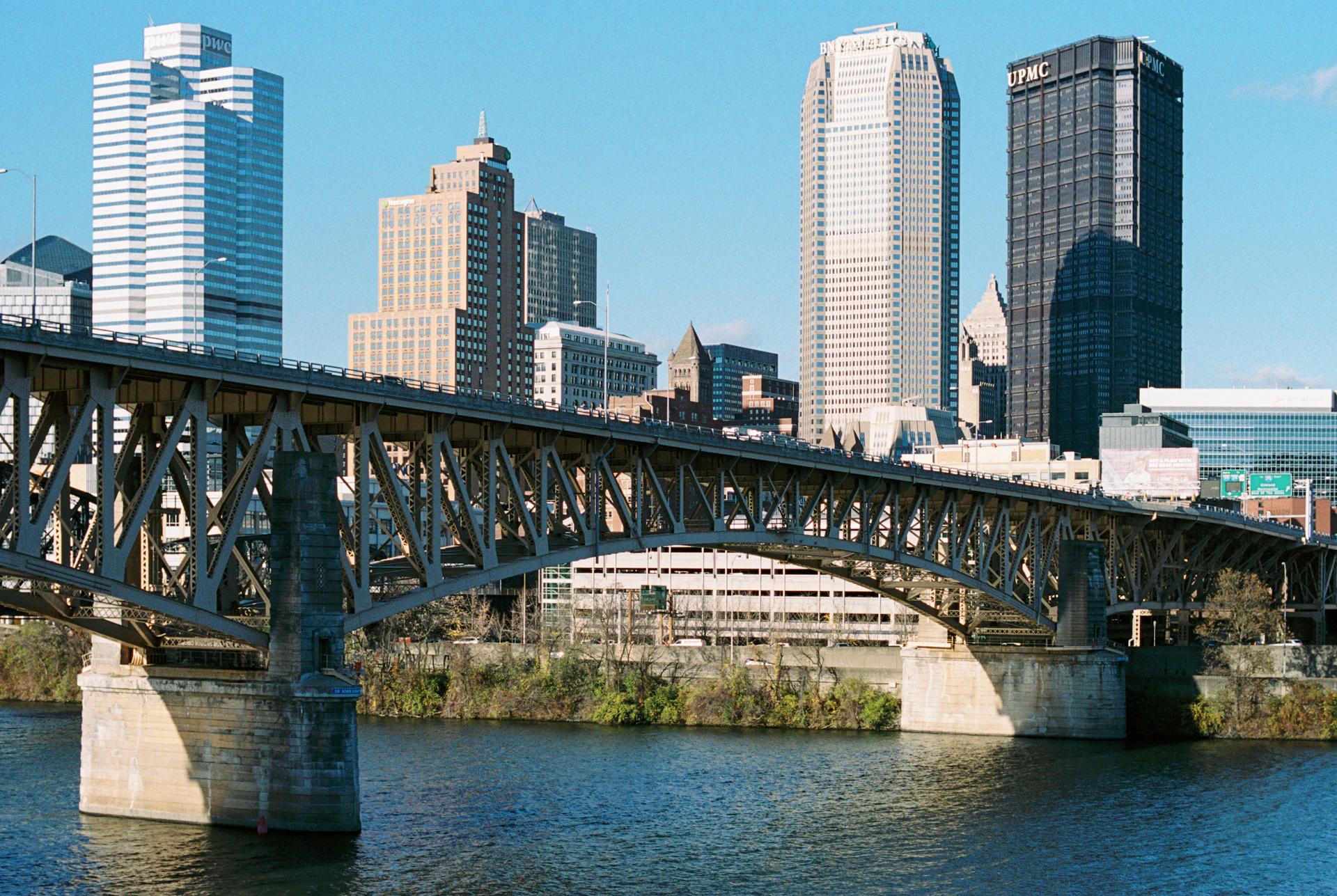A bridge over a river with a city in the background
