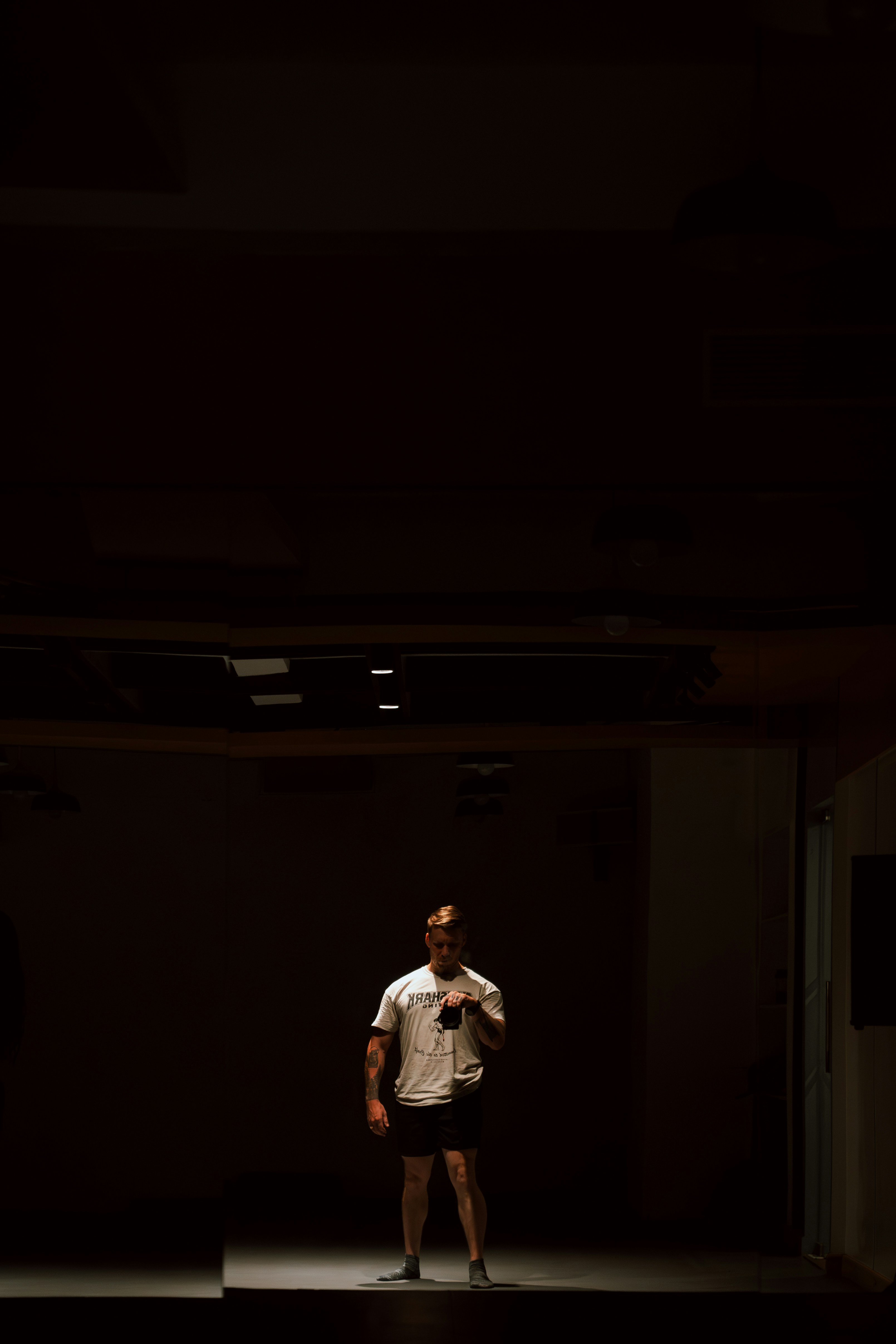 A man standing in a dark room holding a camera