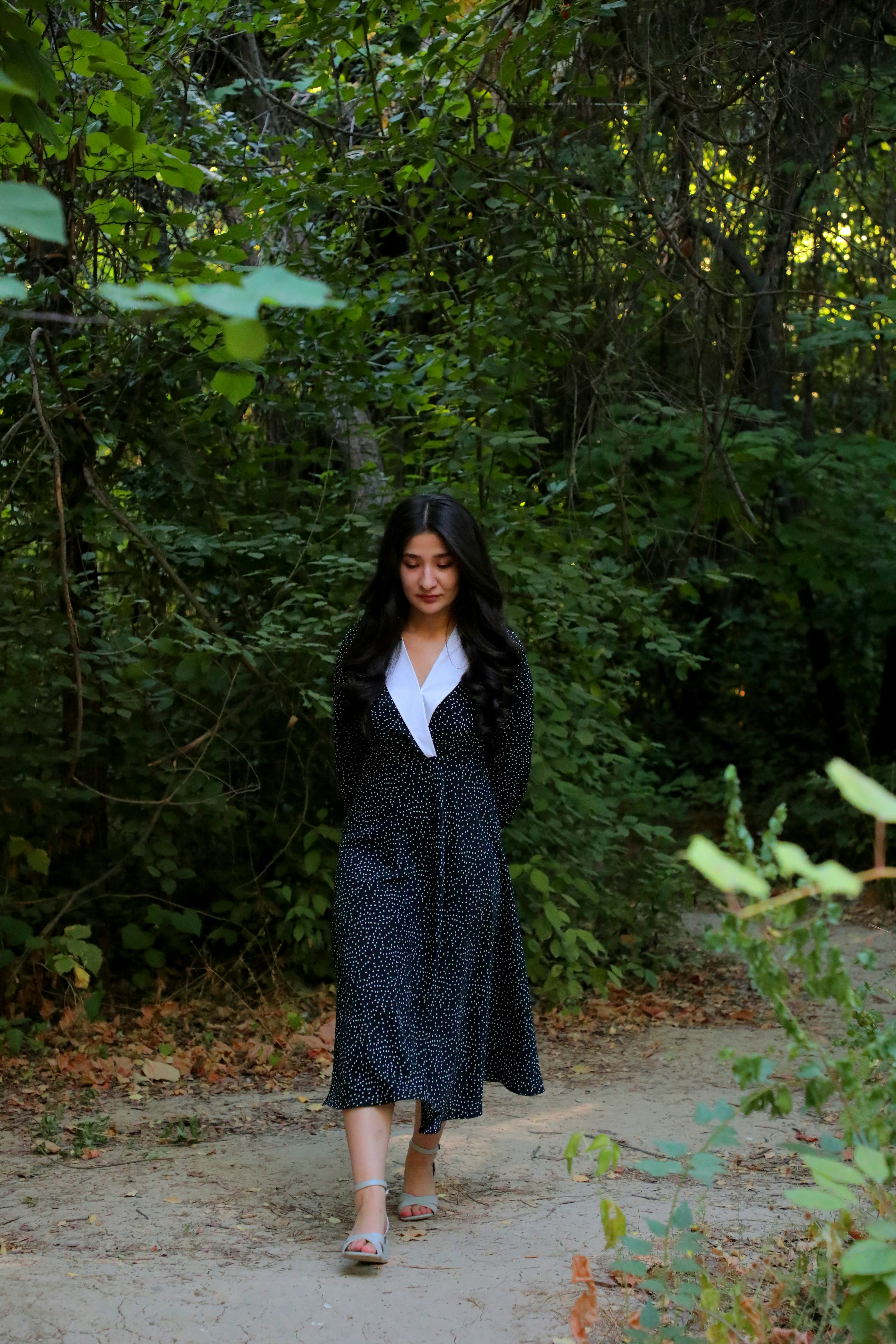 A woman is walking down a path in the woods