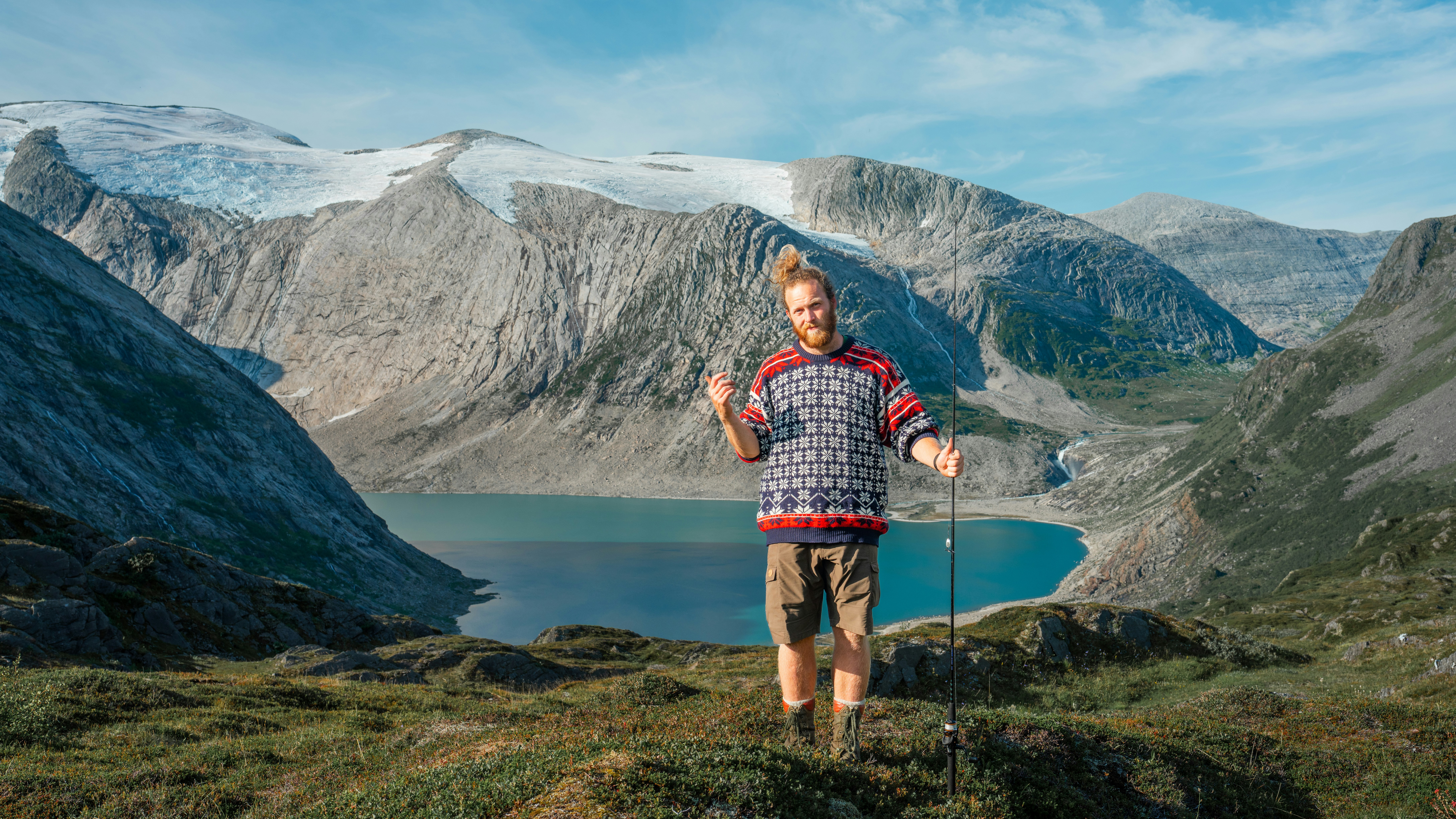 A man hiking up a mountain with a lake in the background