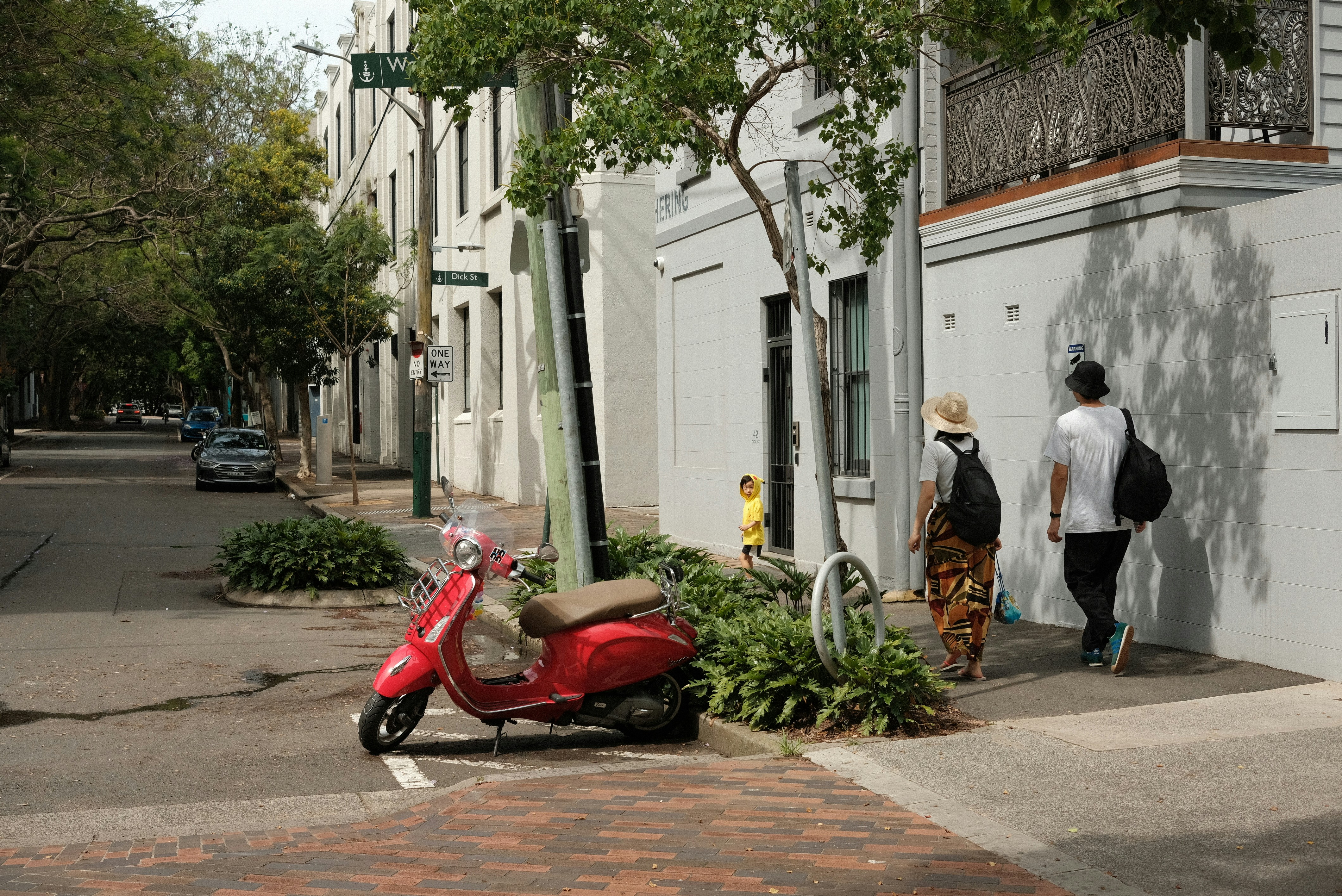 A red scooter parked on the side of a street