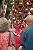 A group of people standing in front of a christmas tree