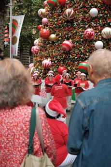 A group of people standing in front of a christmas tree