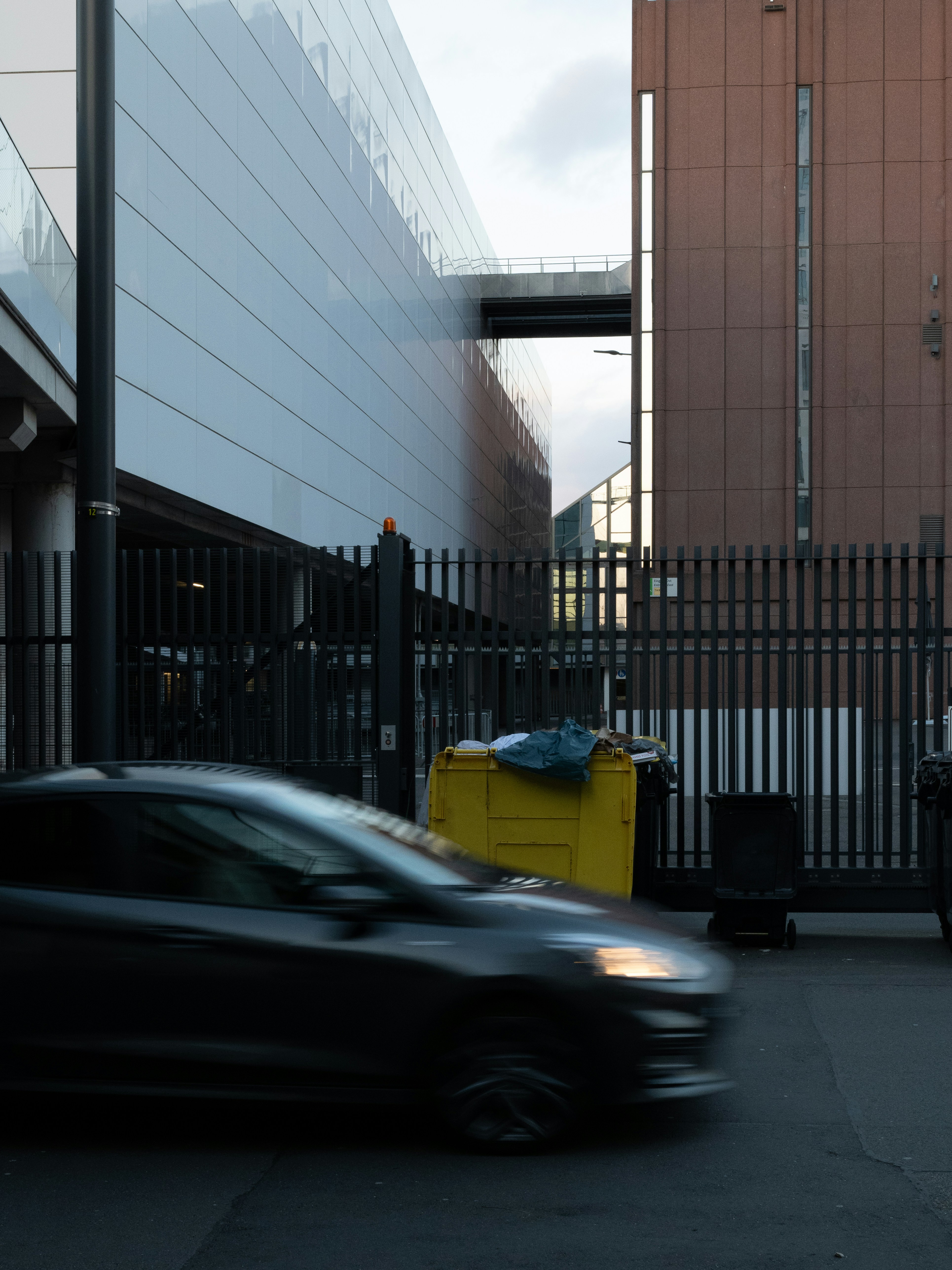 A car driving down a street next to a tall building