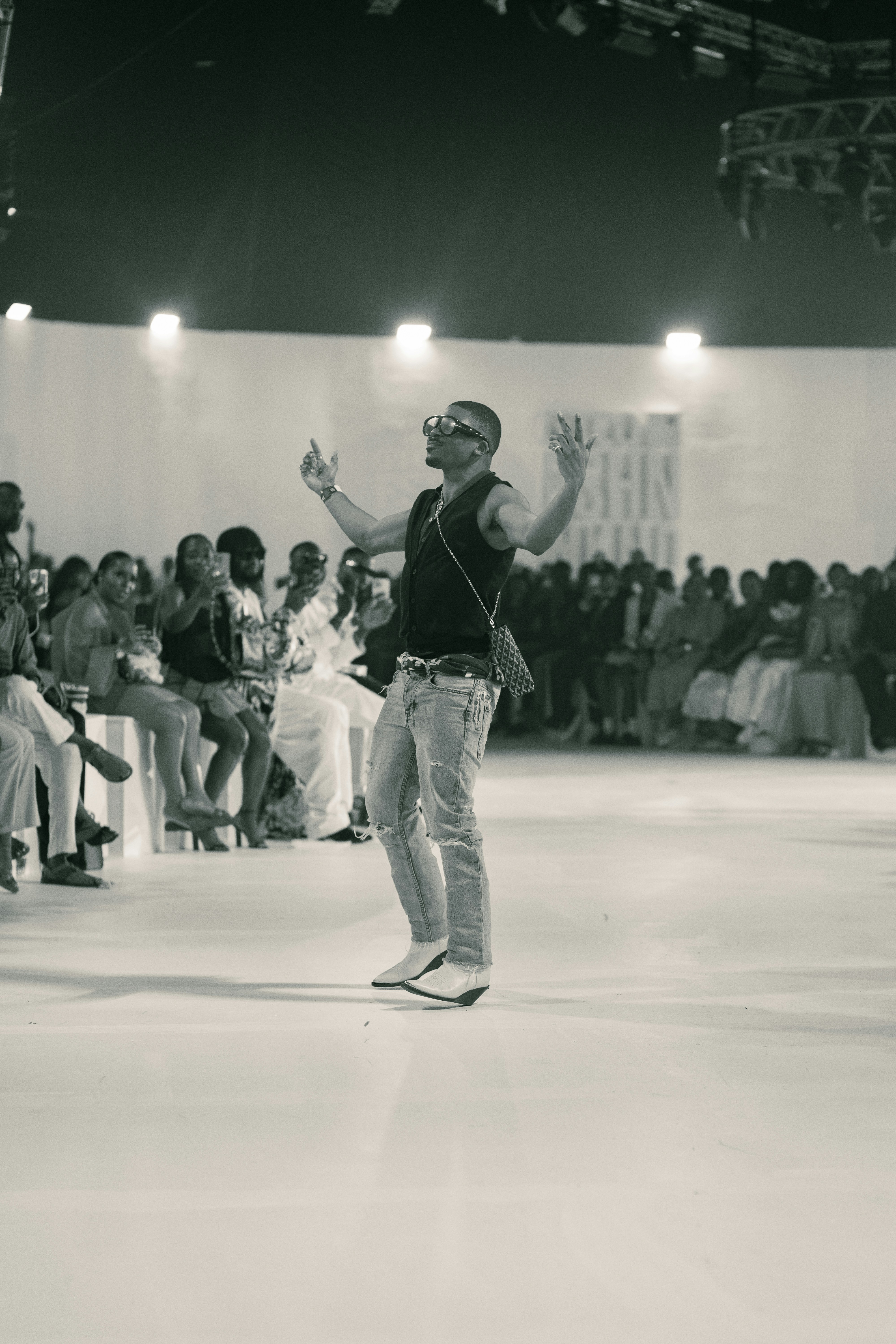 ランウェイに群衆の前に立っている男性