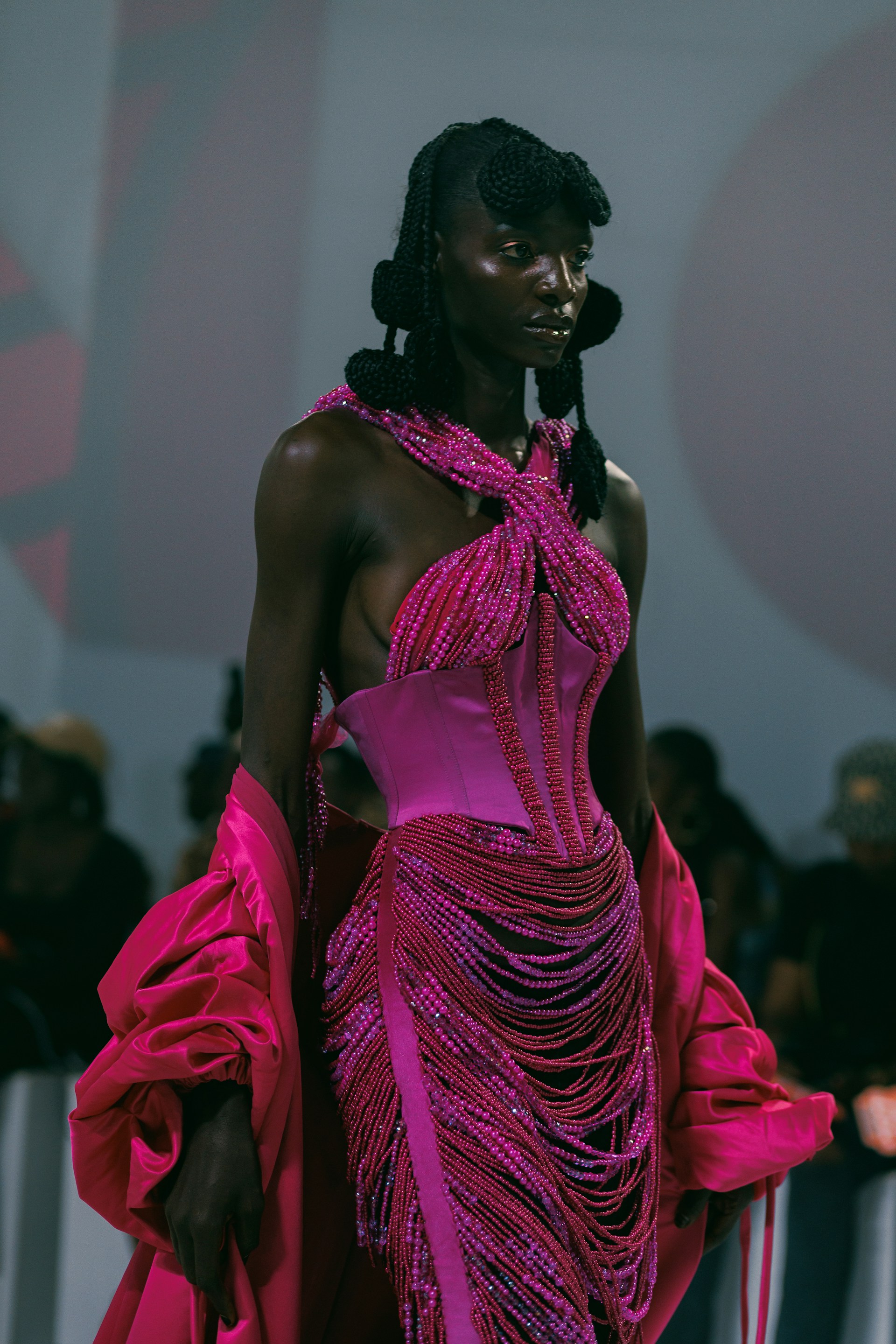 A woman in a pink dress walking down a runway