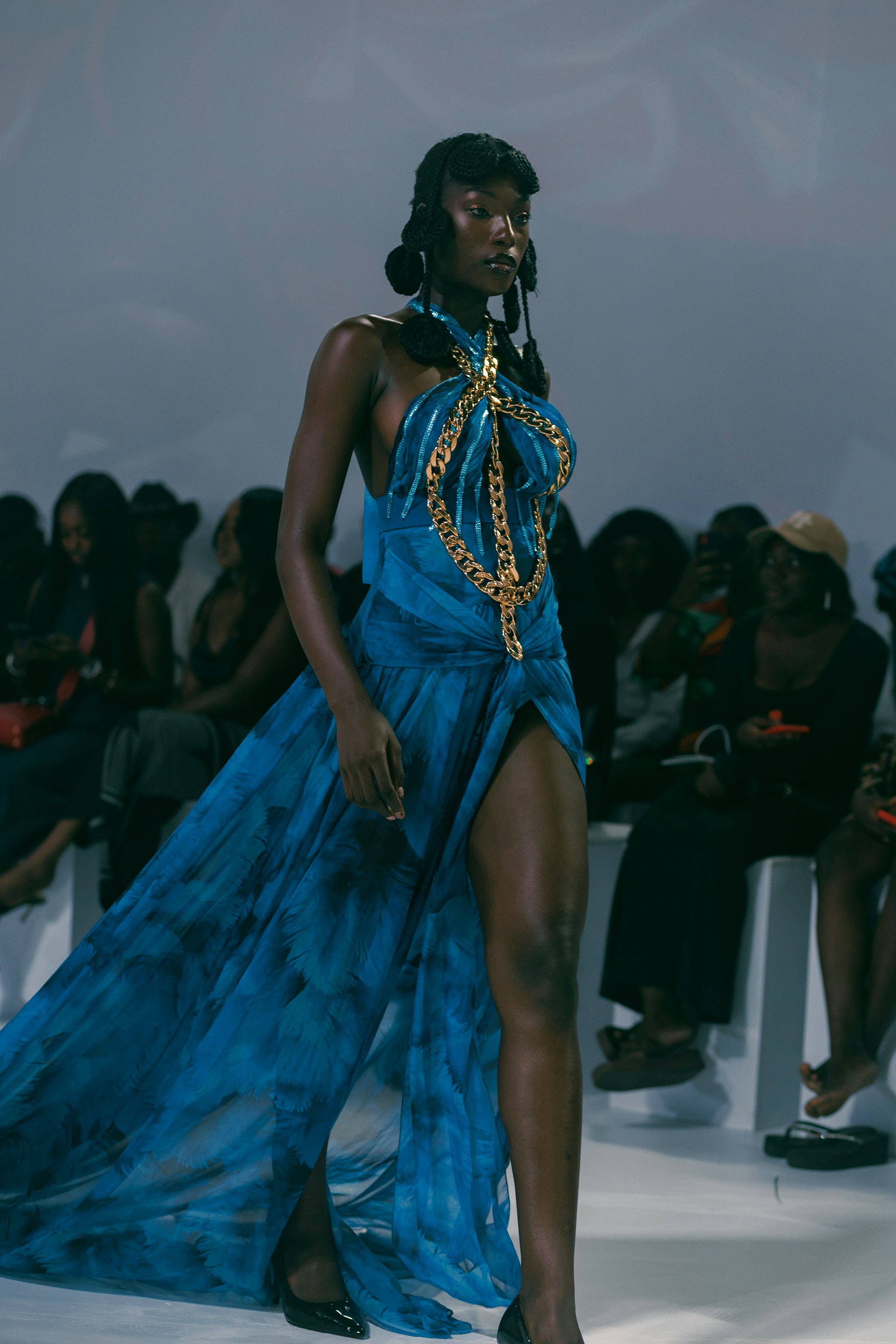 A woman in a blue dress walking down a runway