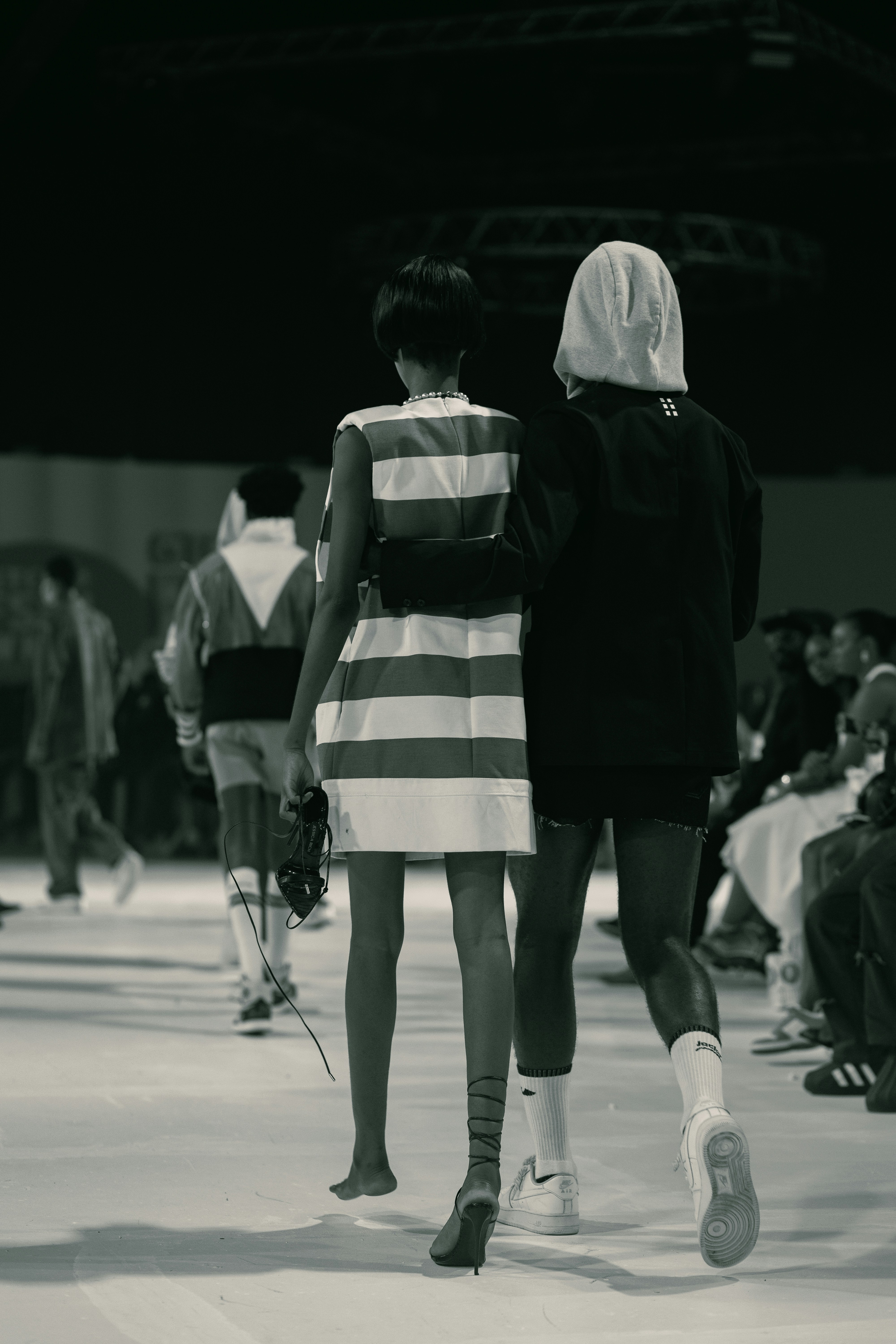 A couple of people walking down a runway