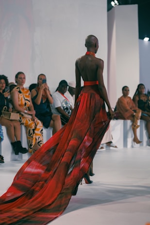 A woman in a red dress walking down a runway