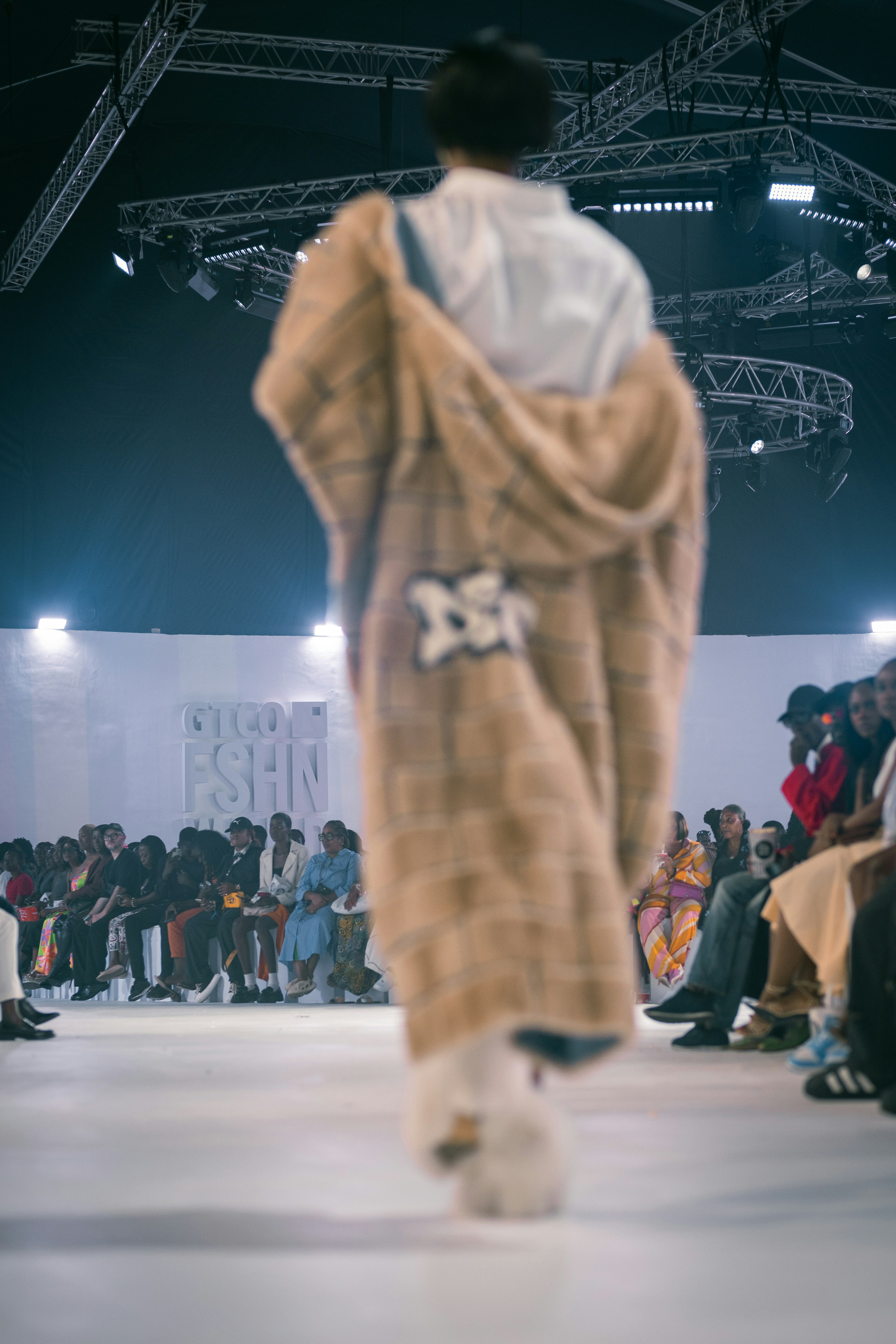 A person in a fur coat walking down a runway