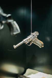 A gun hanging from a hook on a wall