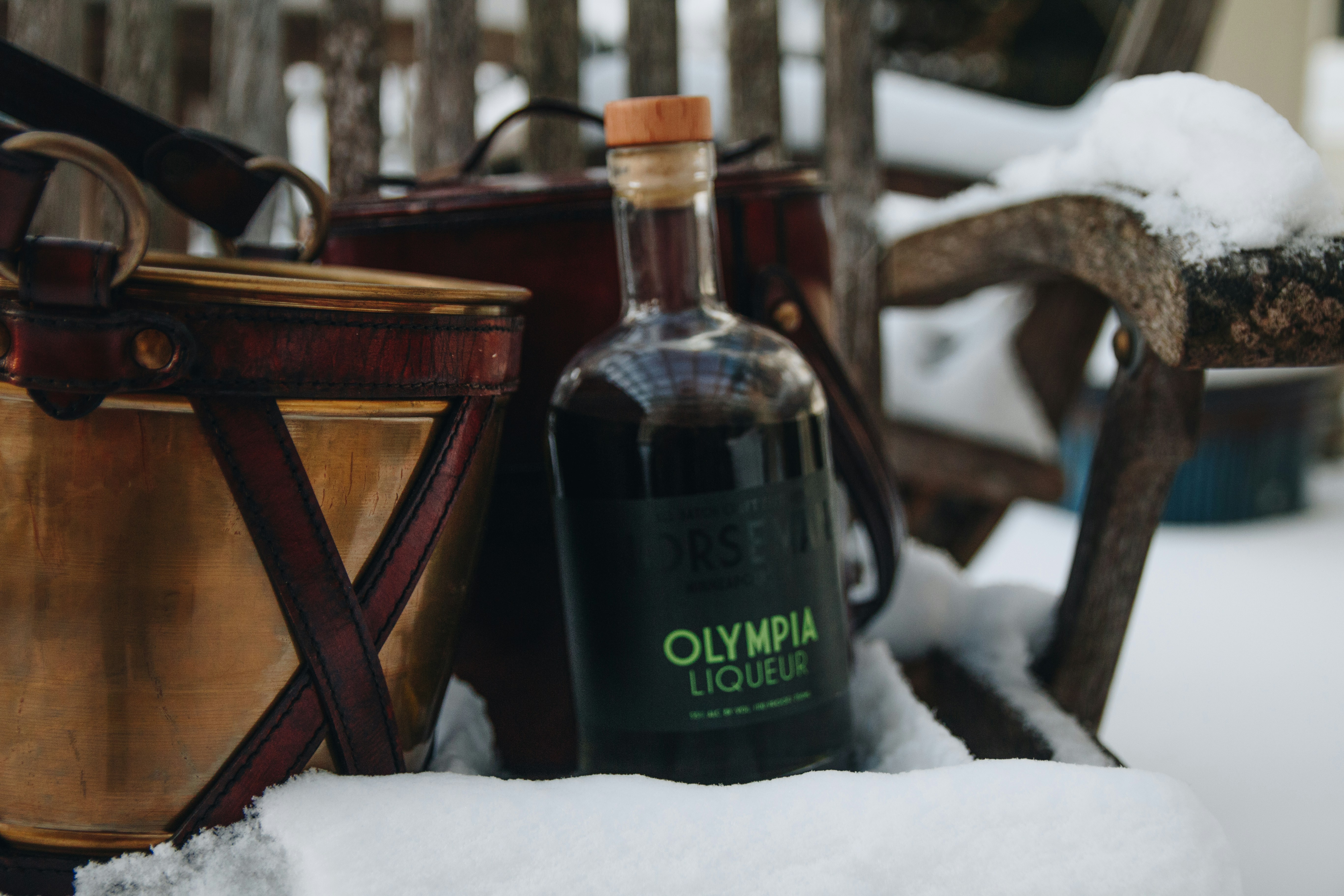 A bottle of olive oil sitting on top of a pile of snow