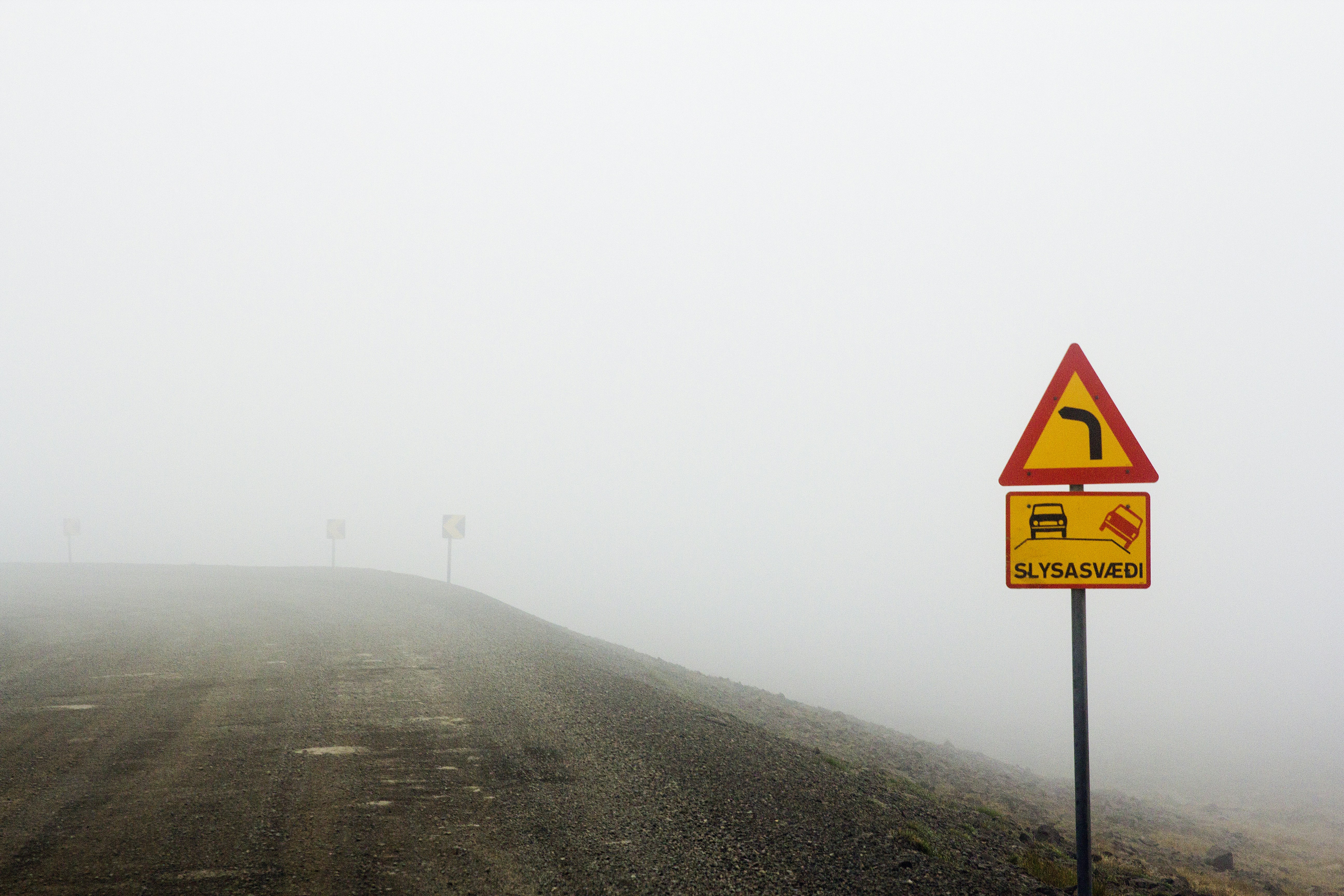 A road sign on a foggy road in the middle of nowhere