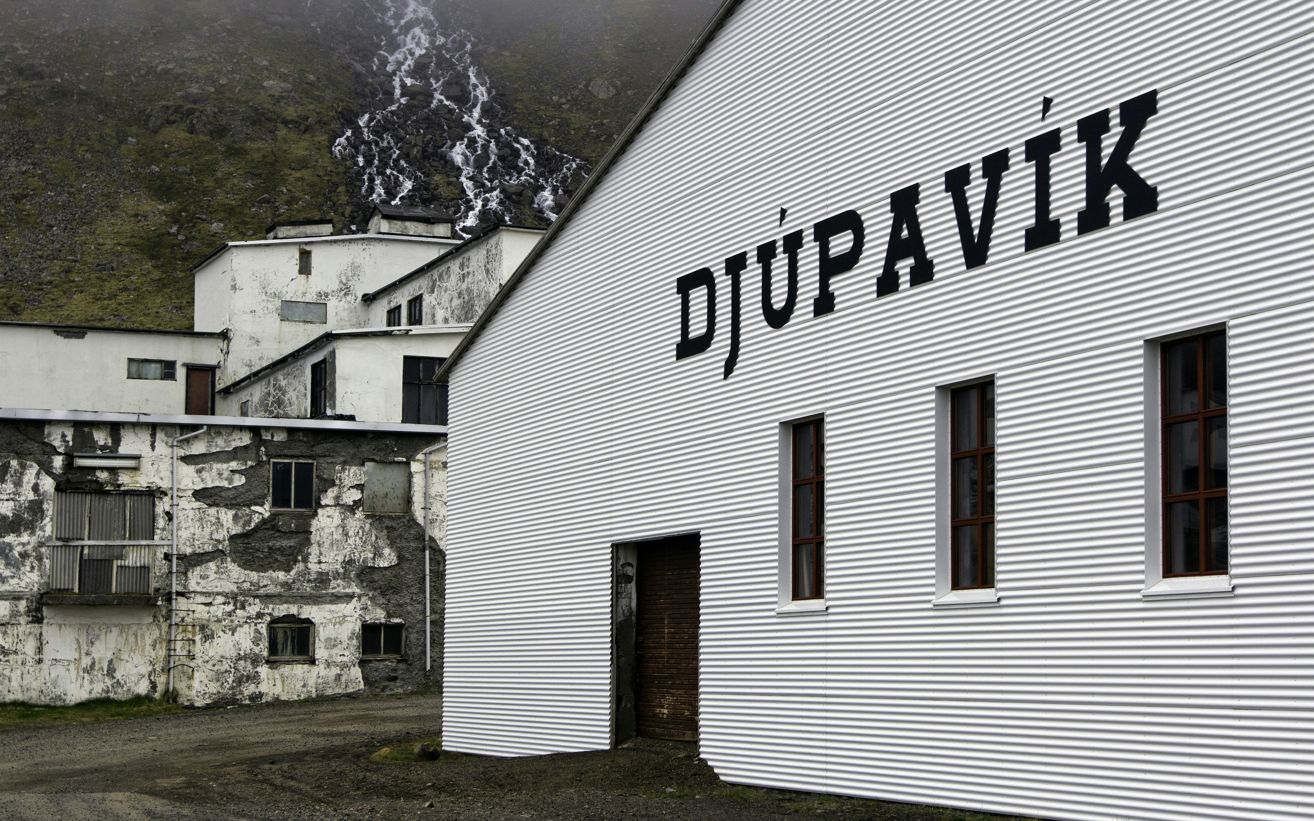 A white building with a sign on the side of it