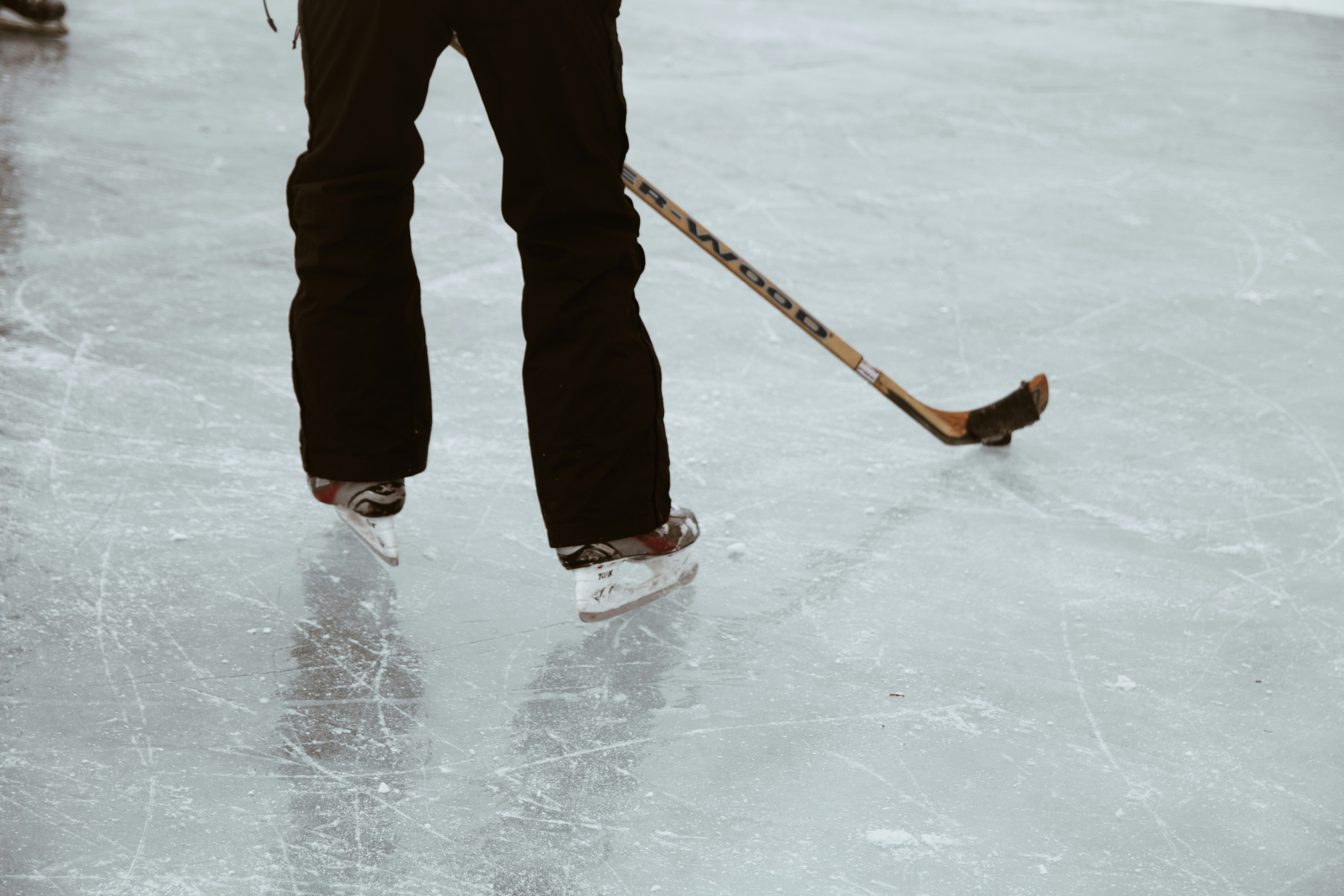 A man standing on a ice rink holding a hockey stick