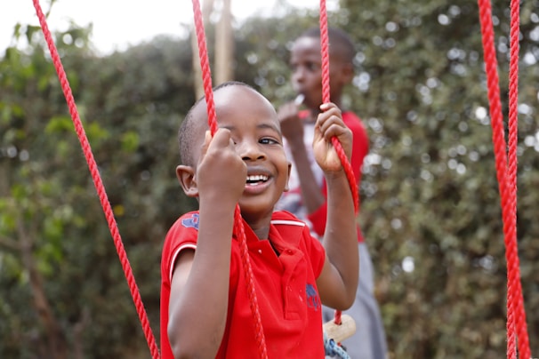 A young boy is swinging on a rope