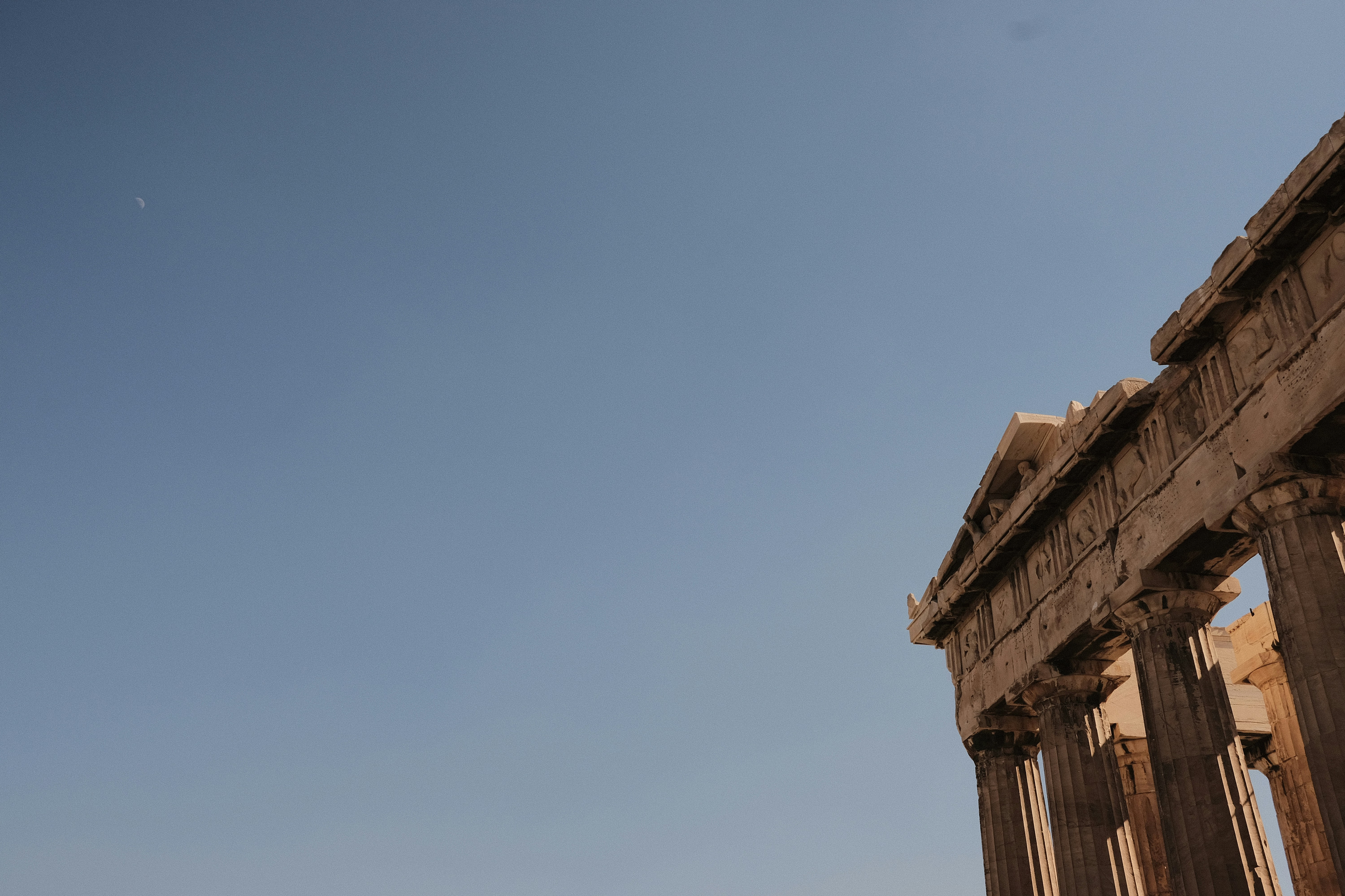 A man flying a kite in front of a building