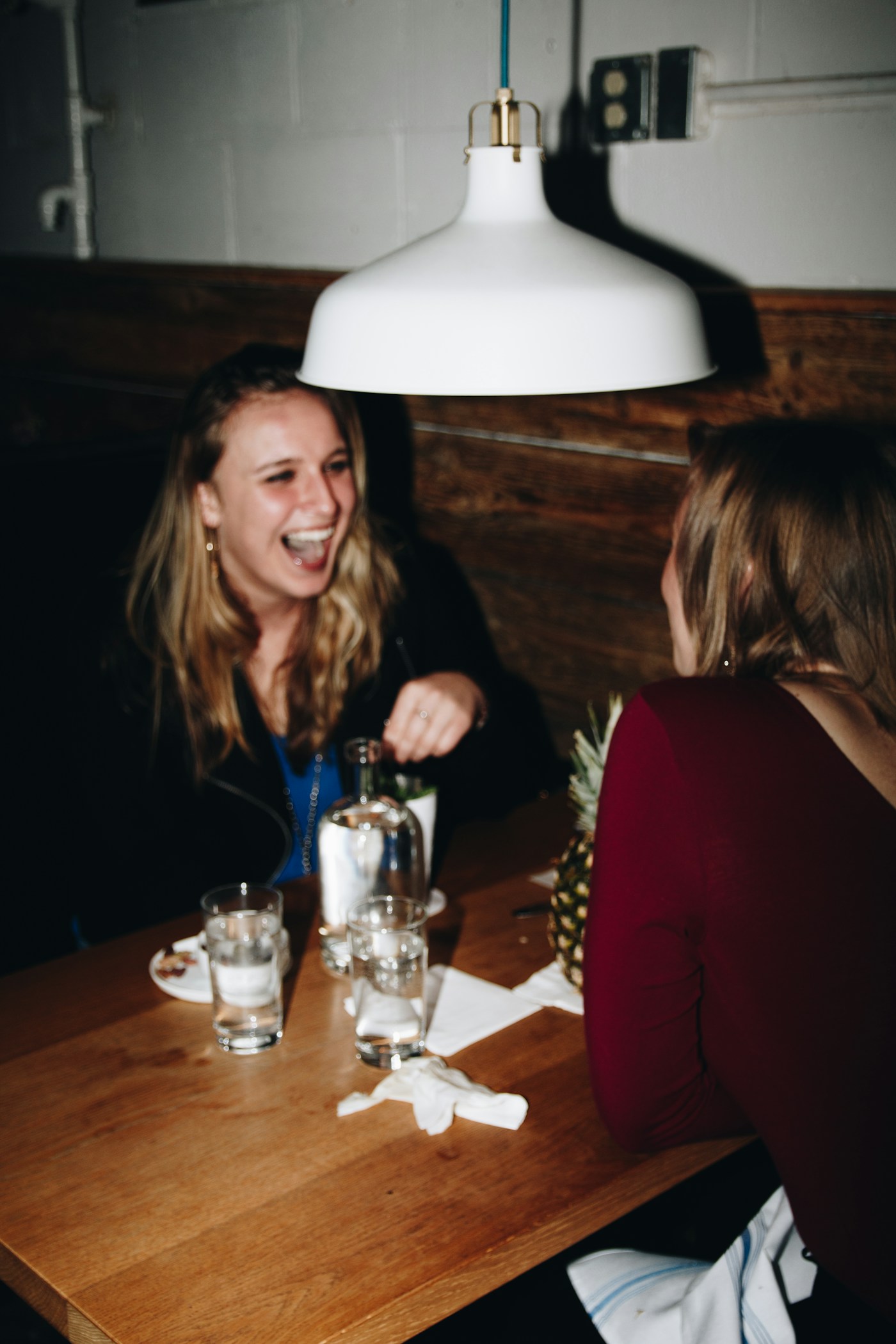 Duas mulheres sentadas em uma mesa de madeira