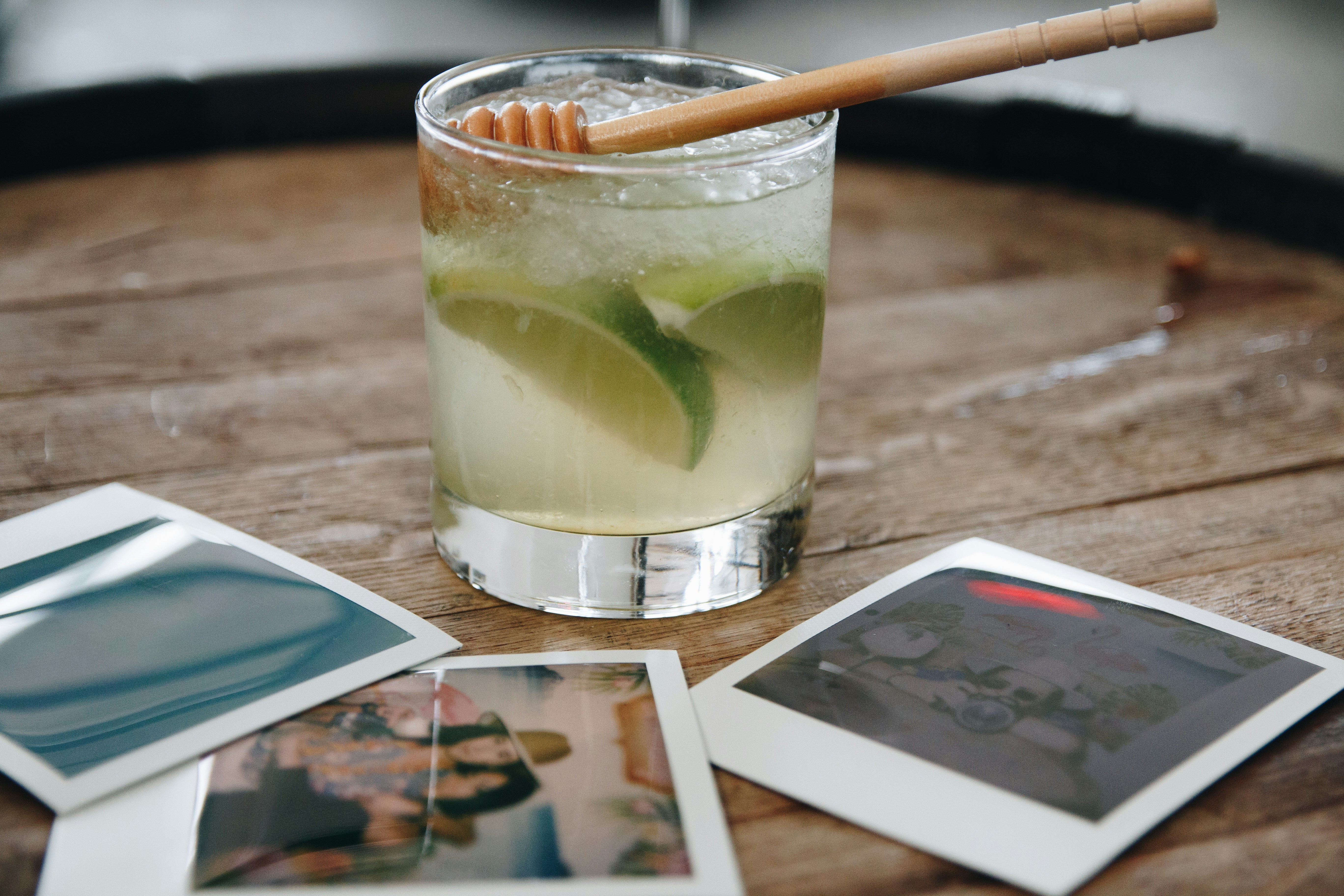 Lime cocktail with honey dipper on a table