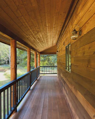 A porch with a wooden floor and railing